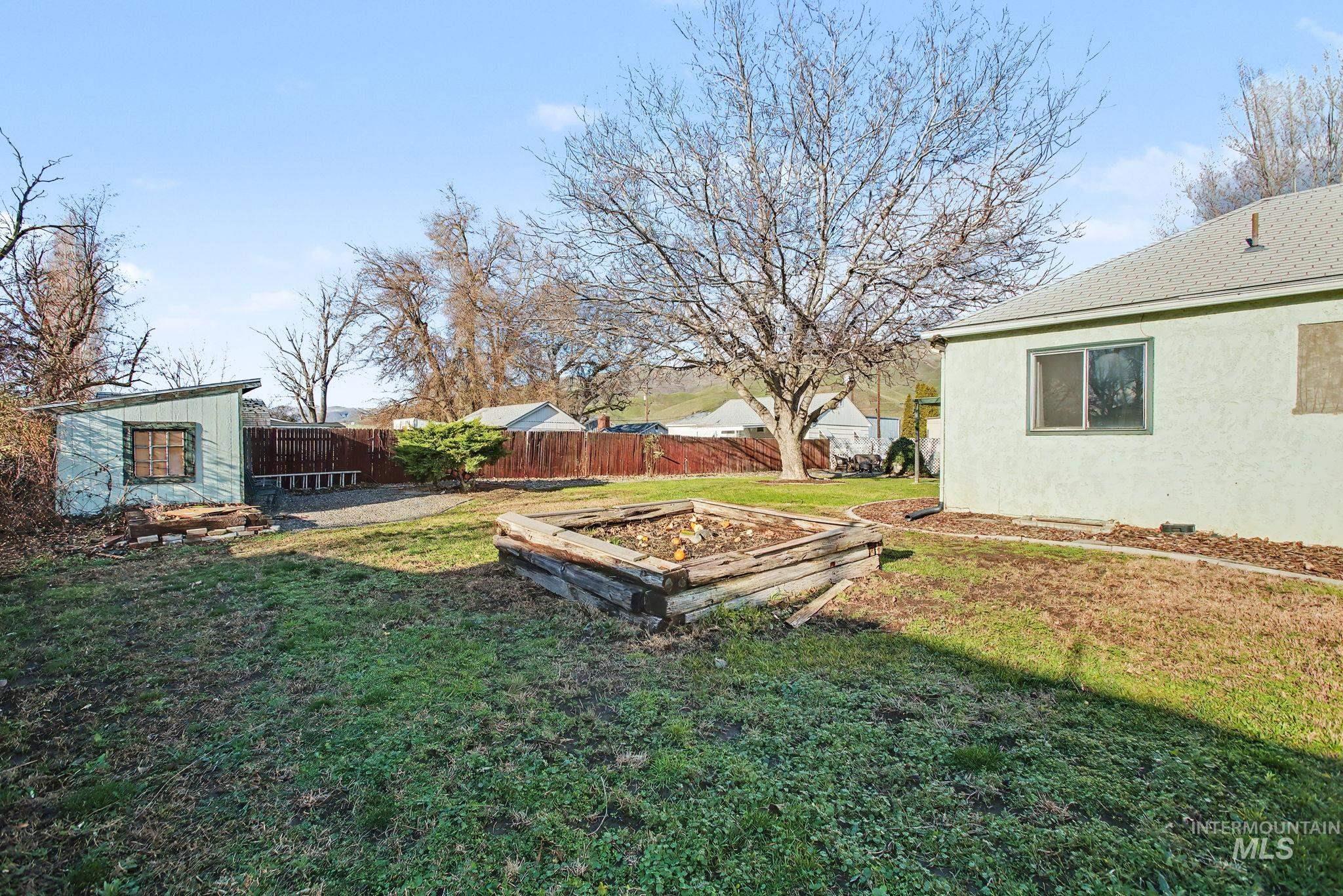 Fenced backyard featuring a vegetable garden