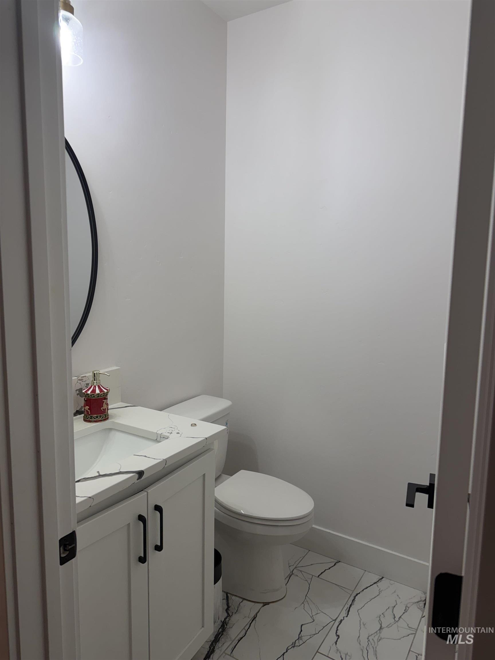 Bathroom featuring light marble finish flooring and vanity
