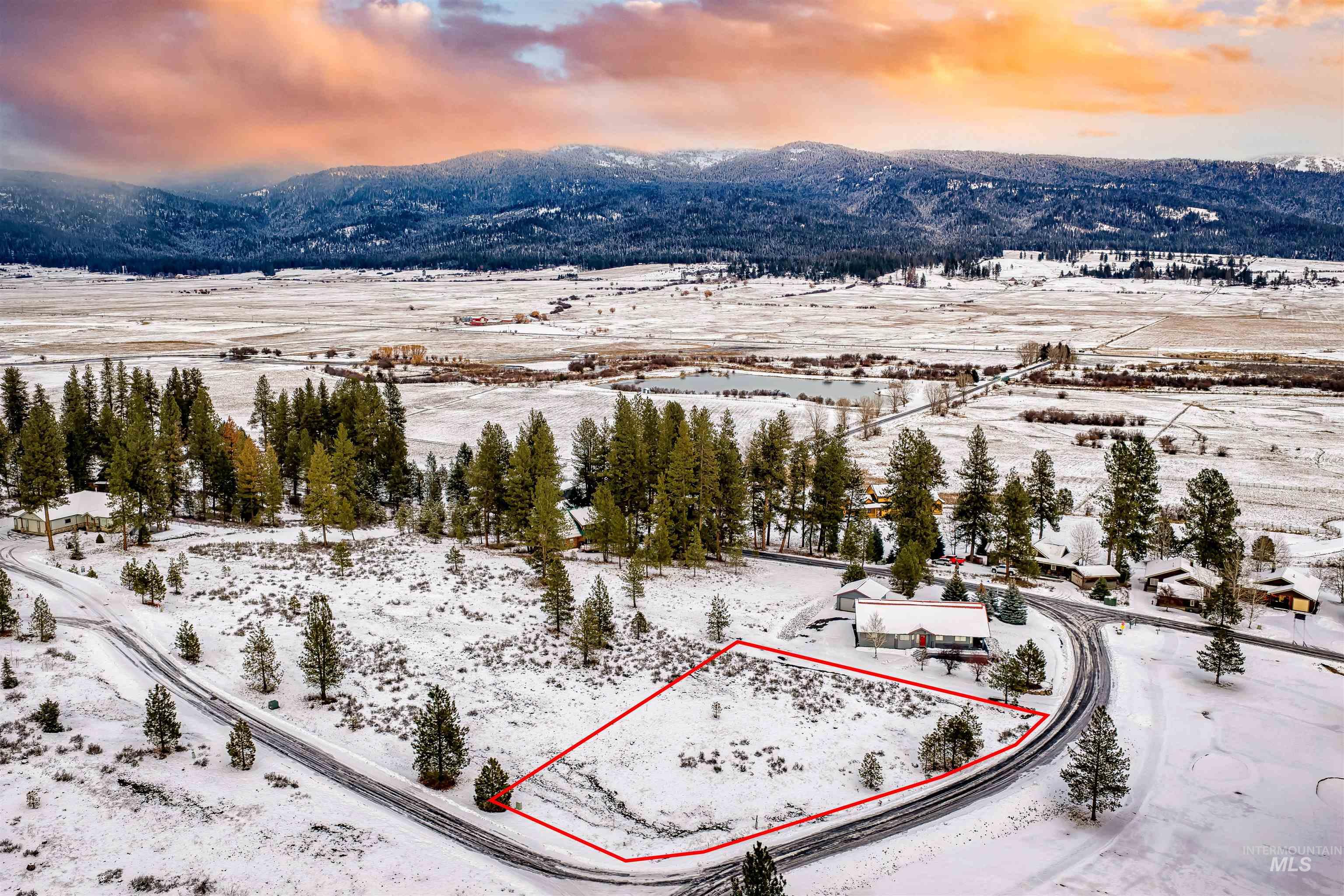 Snowy aerial view with property parcel outlined and a mountain view