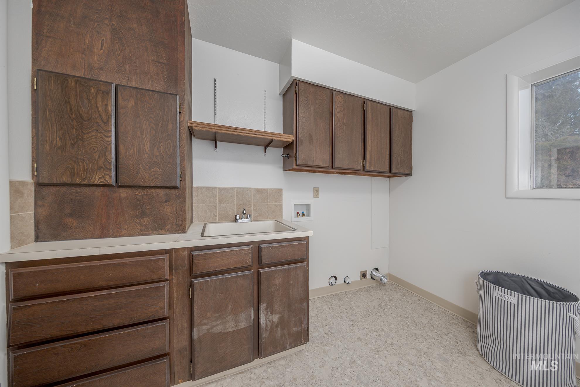 Laundry room with gas dryer hookup, washer hookup, and cabinet space