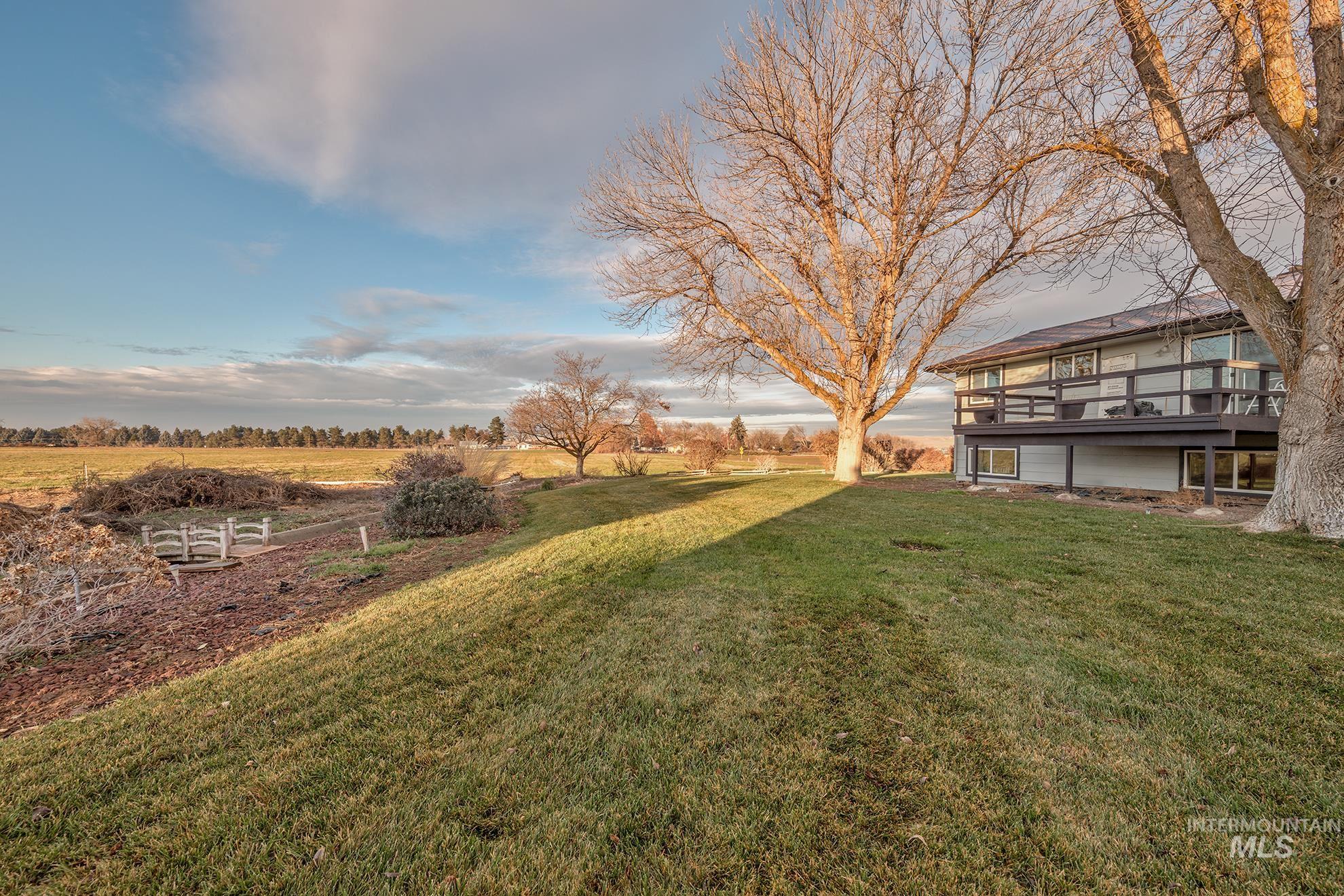 View of green lawn with a deck and a view of countryside