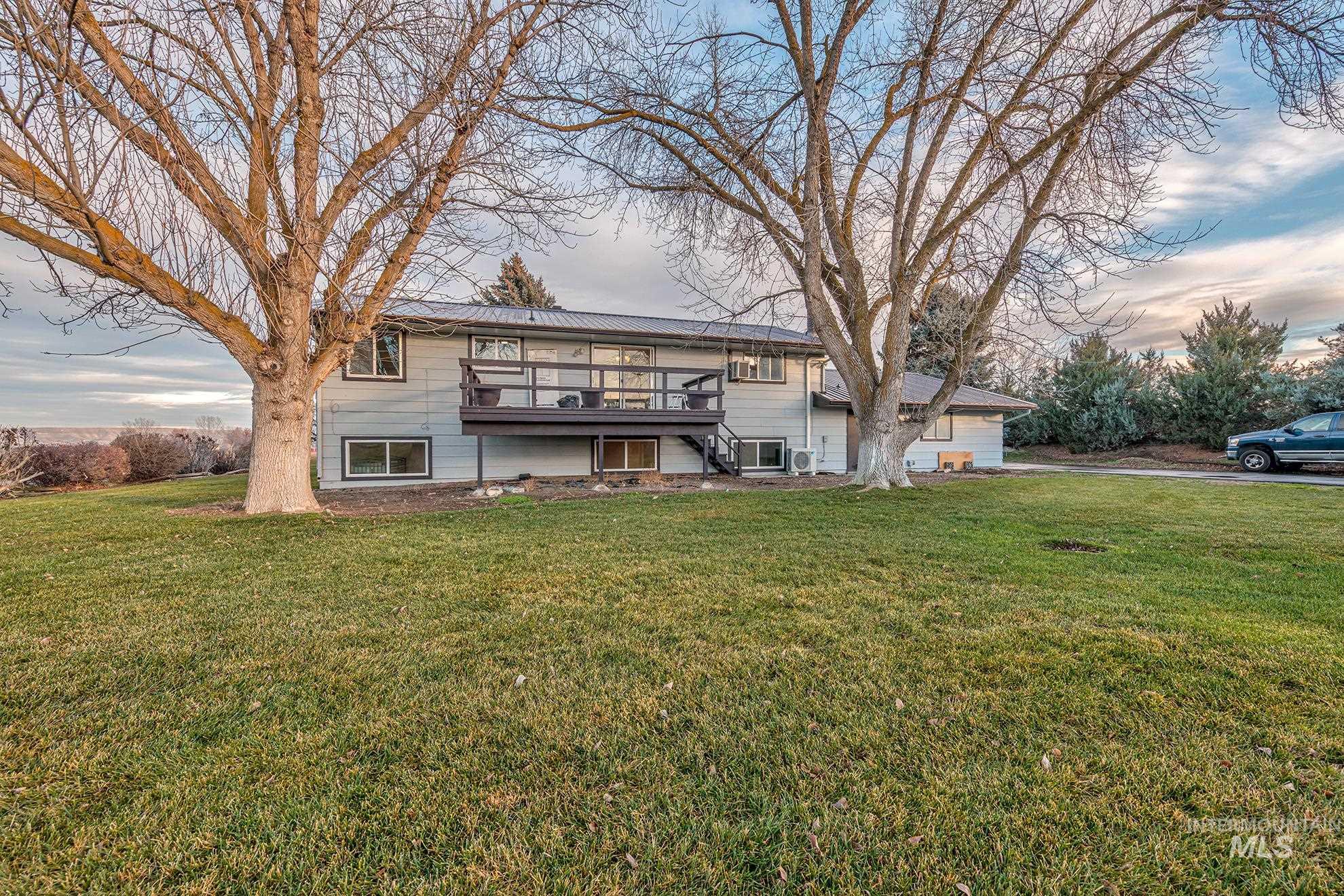 View of back of house featuring a lawn, a wooden deck, and stairway