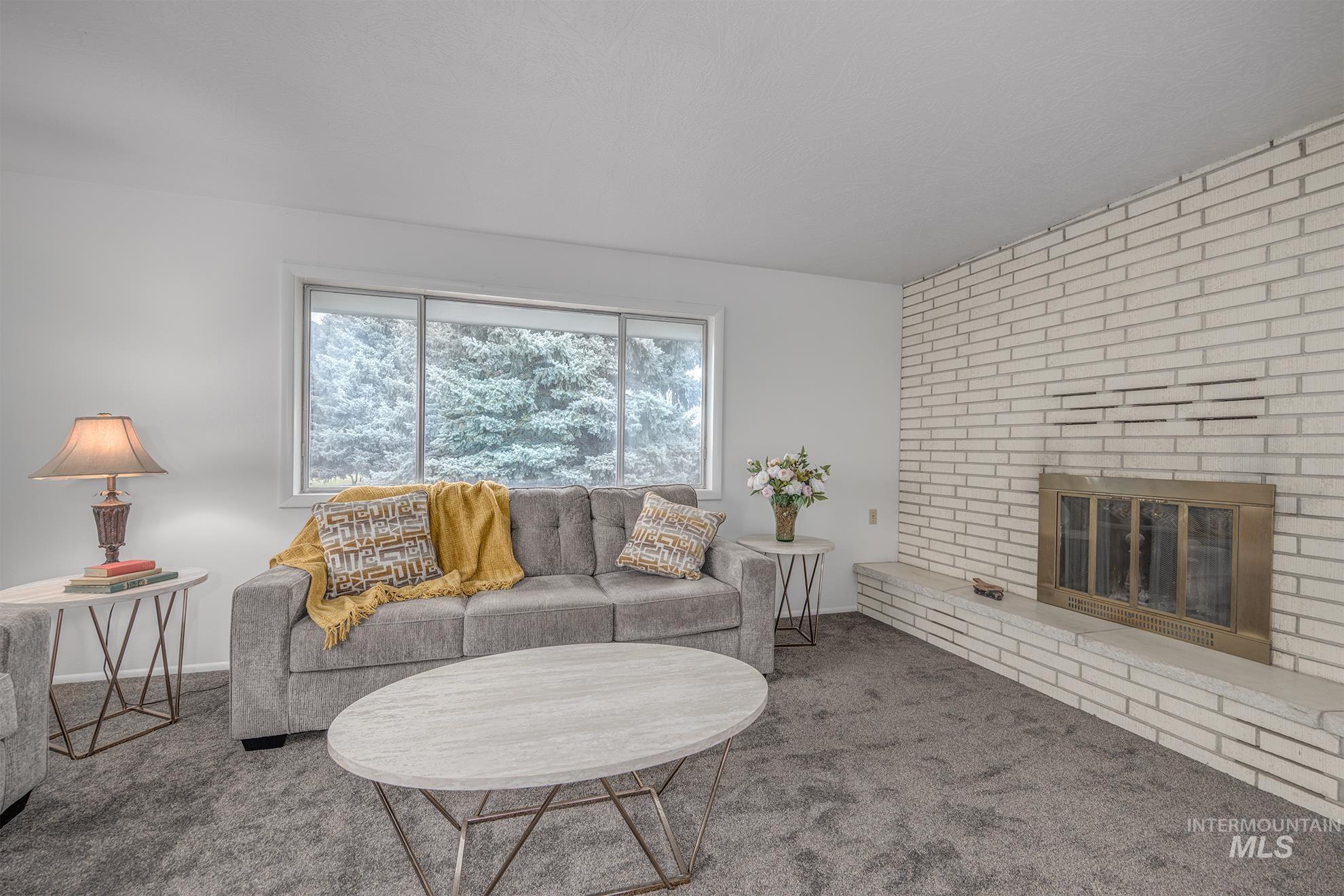Living area featuring carpet floors and a brick fireplace