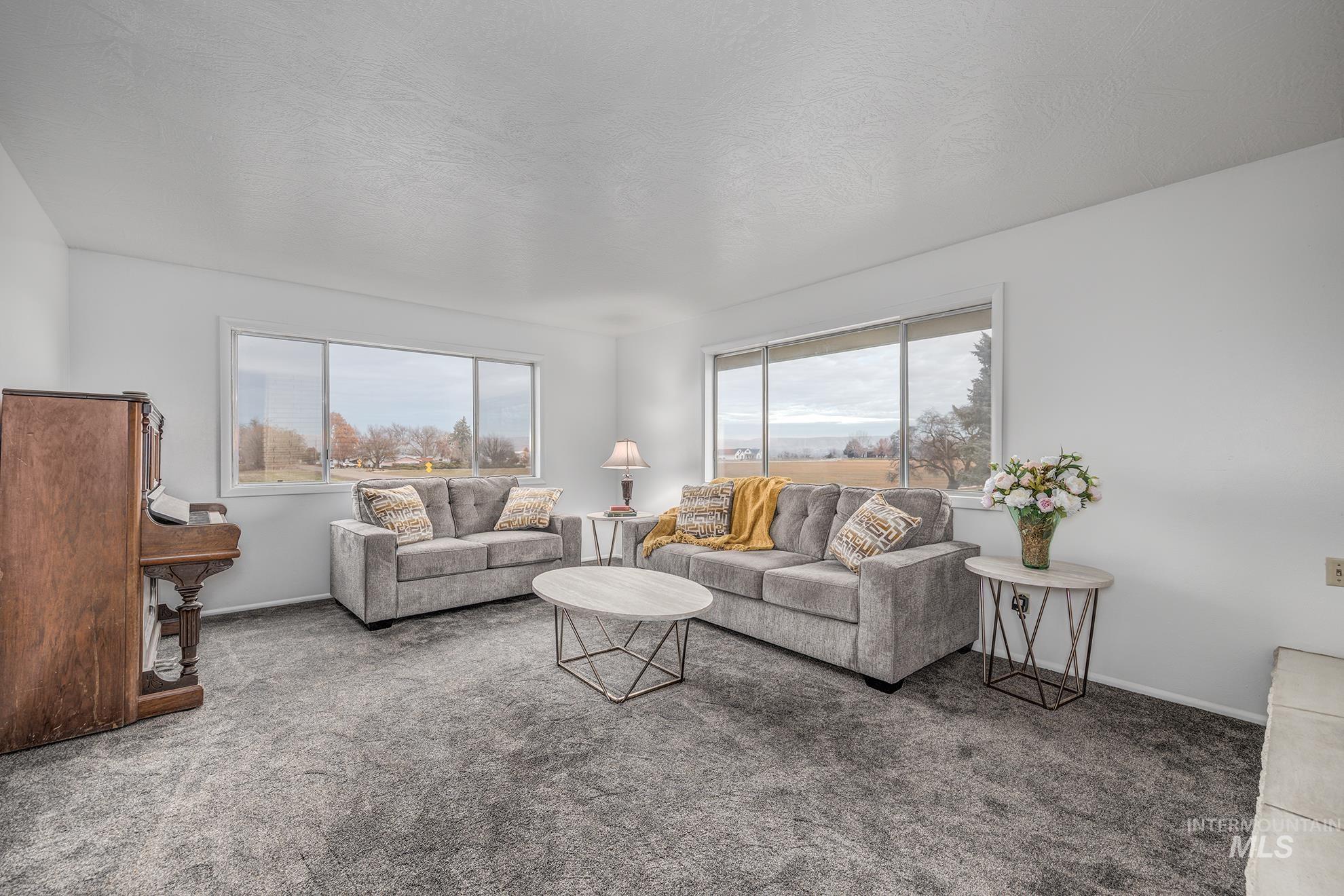 Carpeted living area with a textured ceiling and baseboards