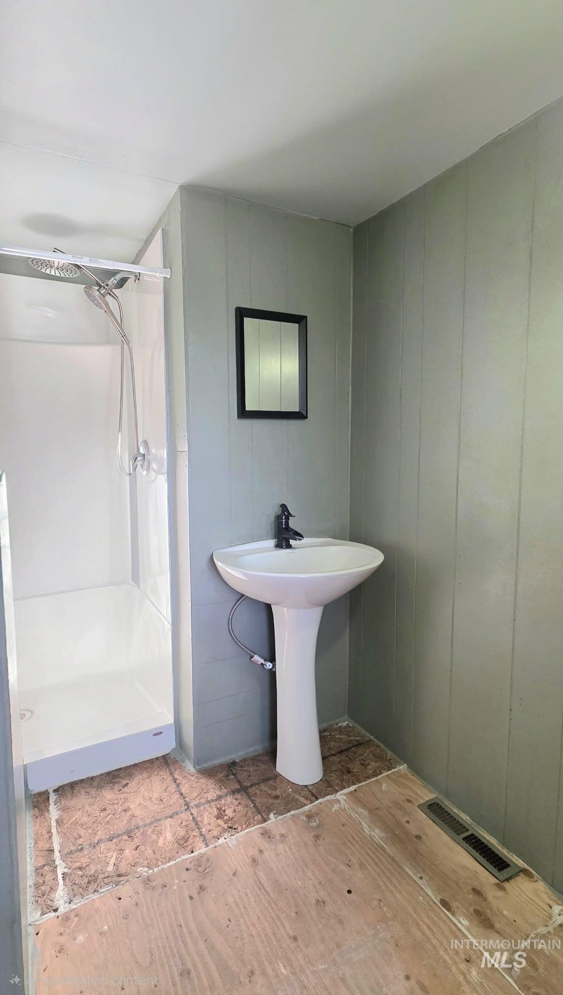 Full bath featuring a shower stall and light wood-type flooring