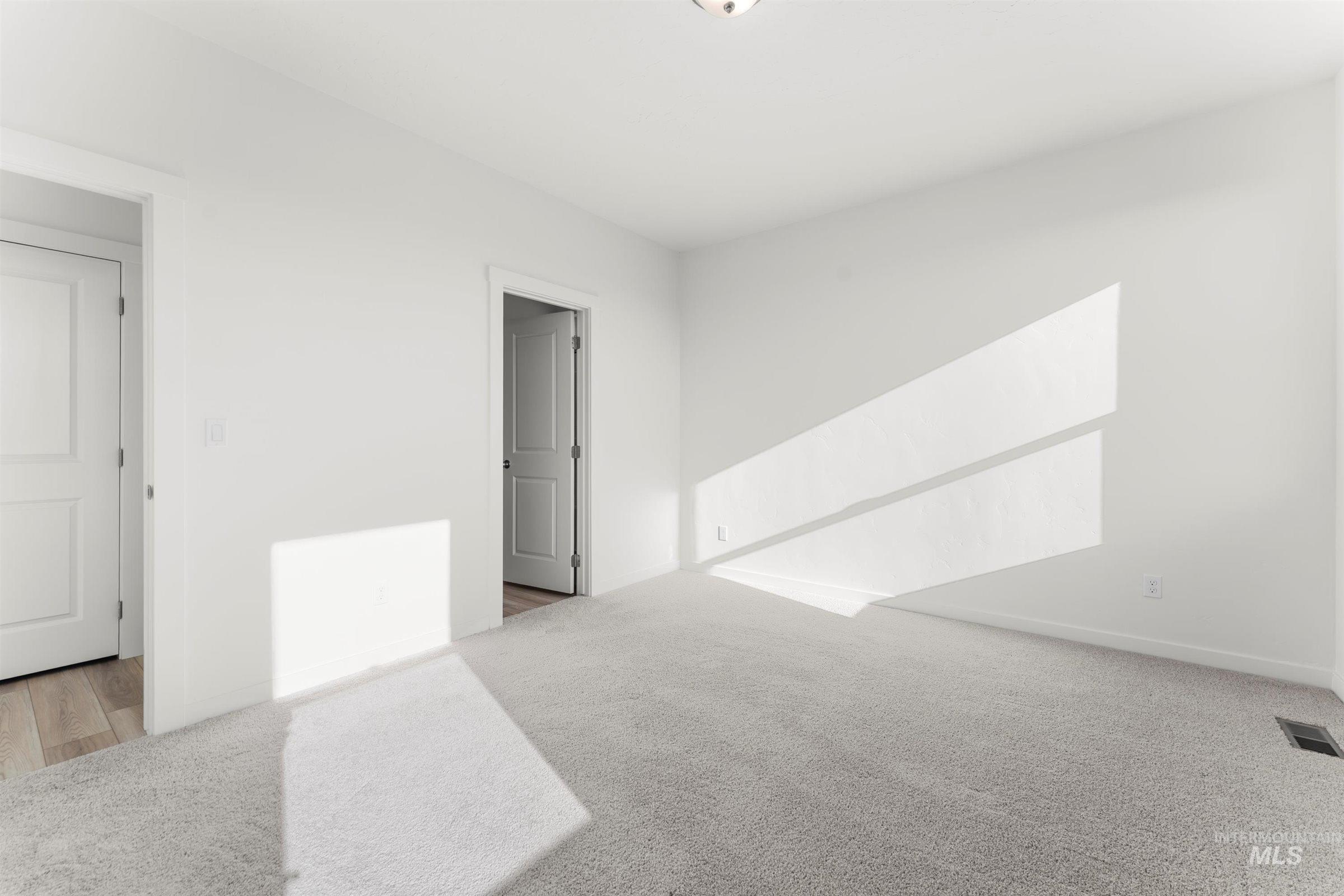 Unfurnished room with light colored carpet and baseboards