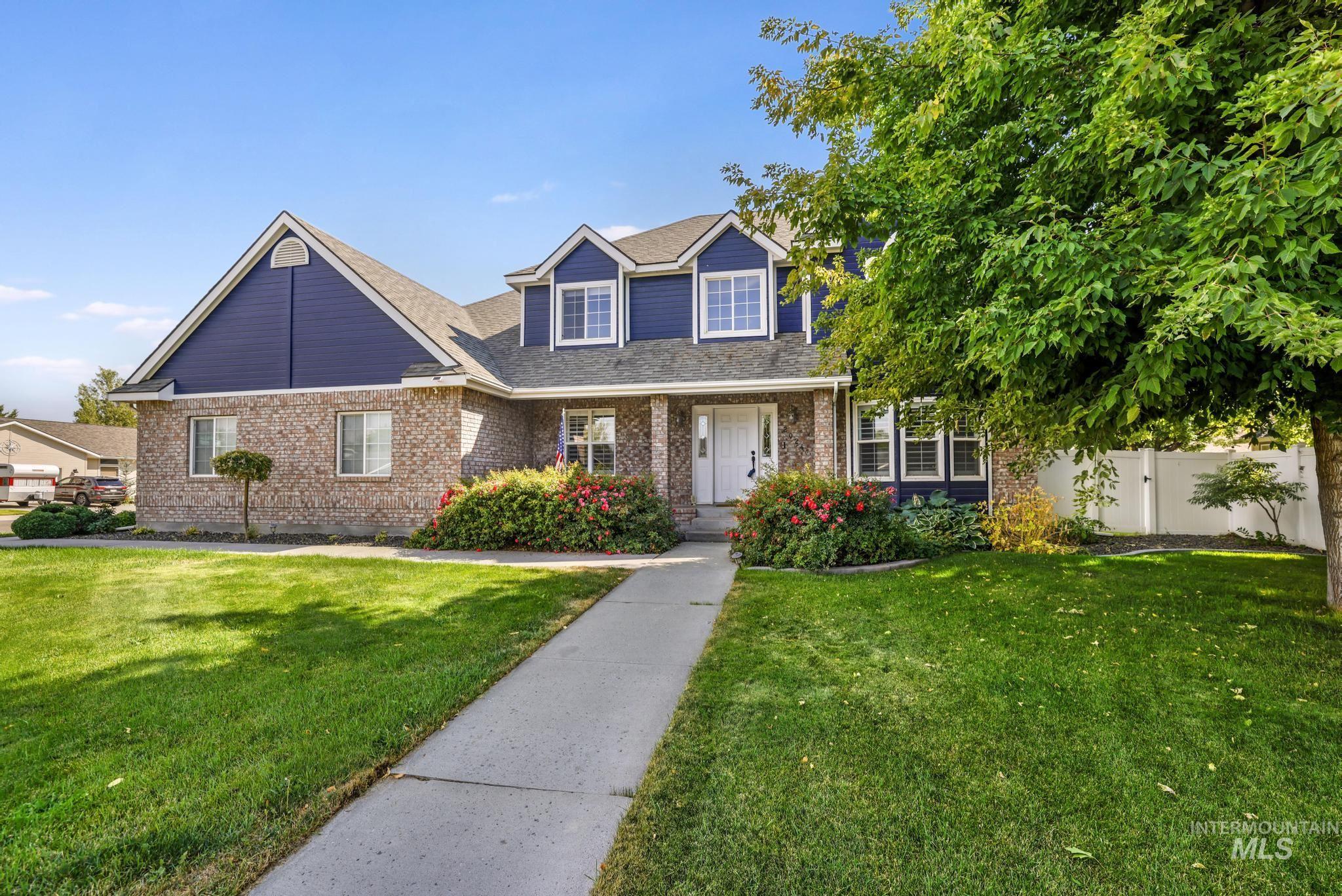 Traditional home featuring a front lawn, brick siding, a porch, and roof with shingles