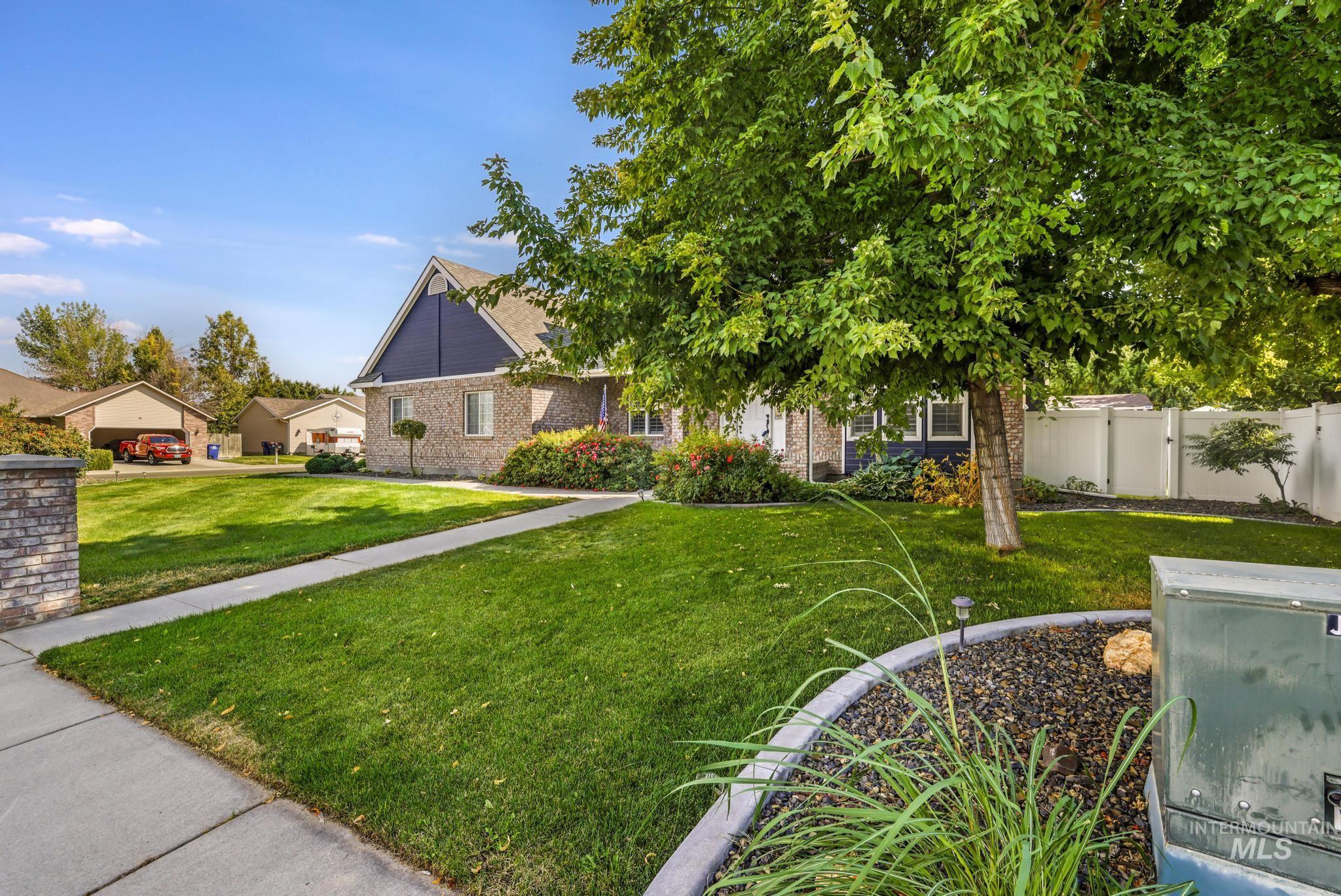 View of property hidden behind natural elements with a residential view and brick siding