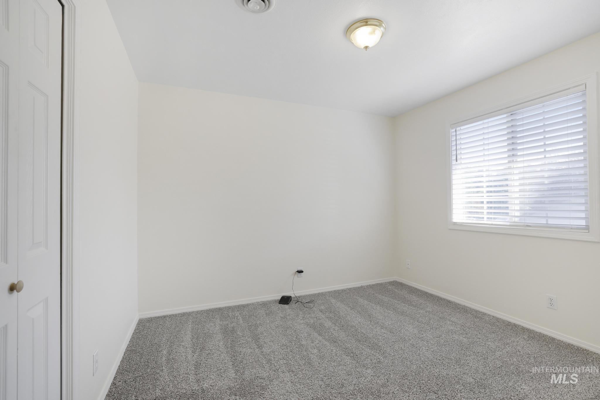Carpeted spare room with baseboards