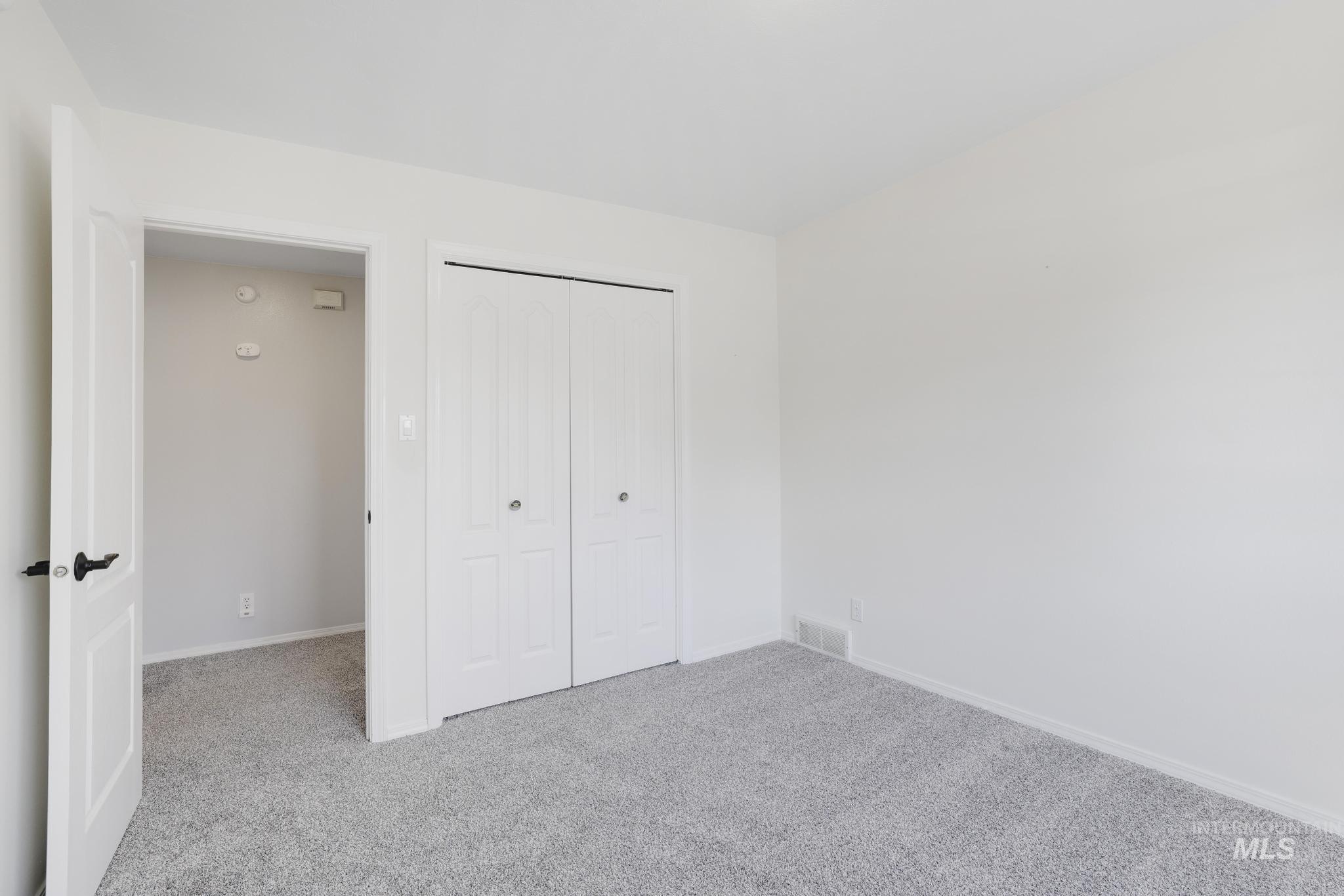 Unfurnished bedroom with carpet and a closet