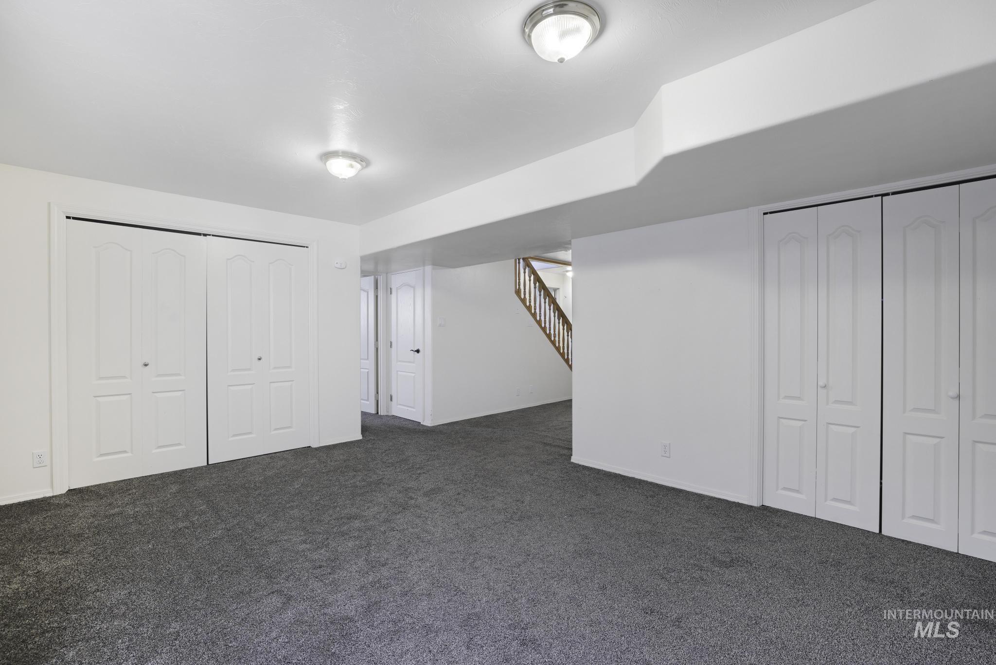 Finished basement with stairs and dark carpet