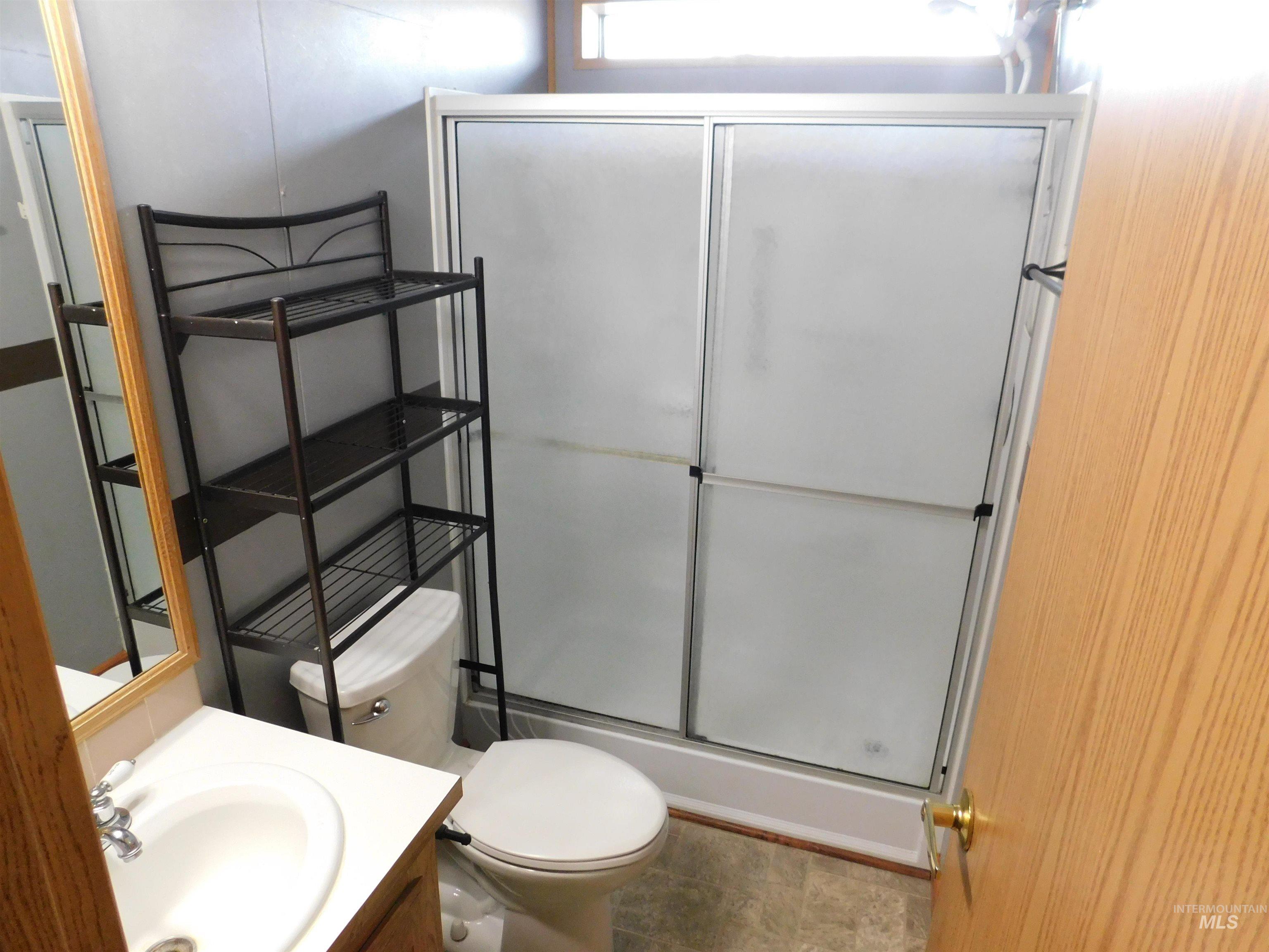 Full bathroom featuring vanity and a shower stall