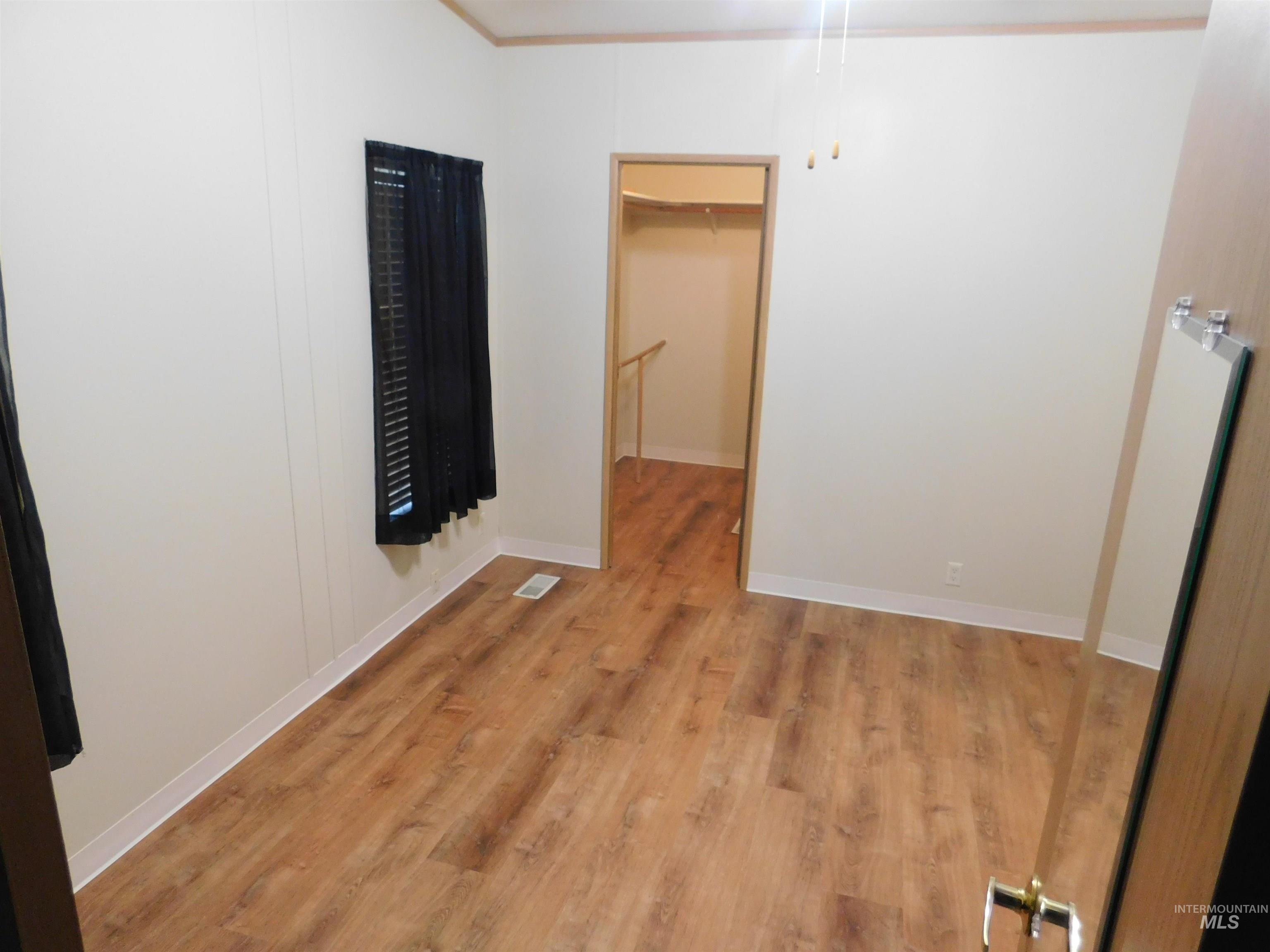 Unfurnished room featuring light wood-type flooring and baseboards