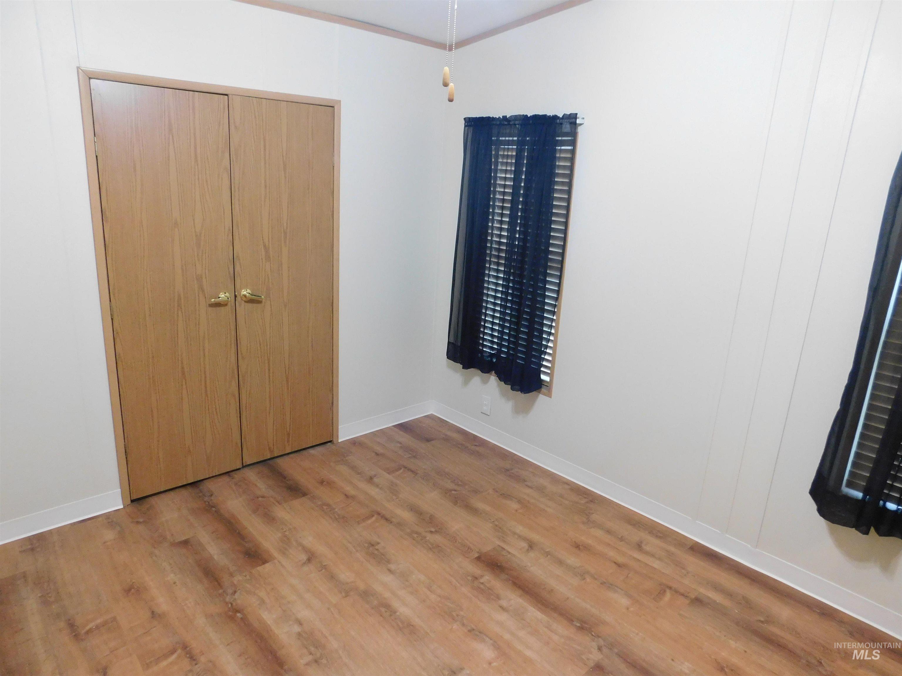 Unfurnished bedroom with light wood-style floors and a closet