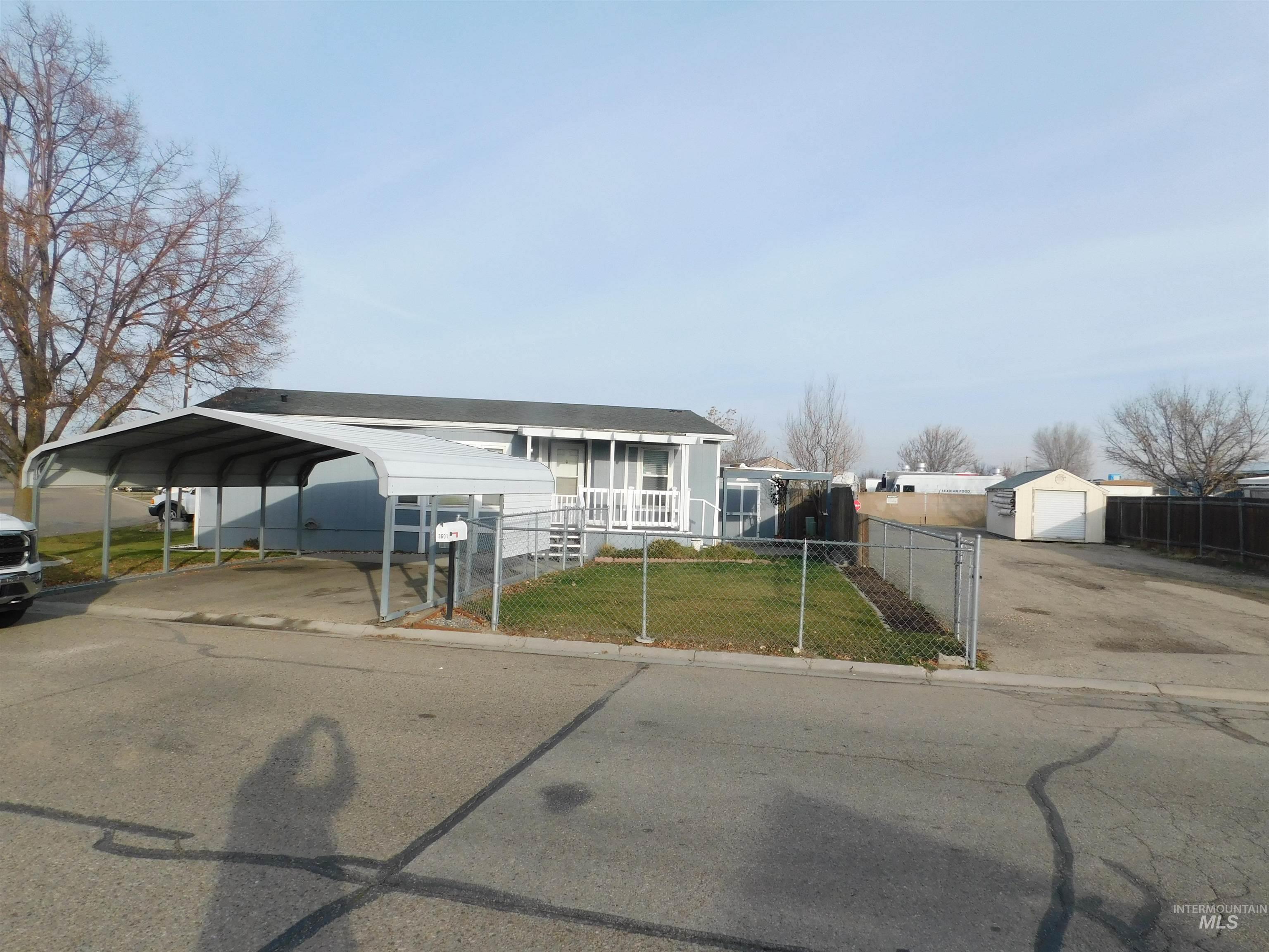 View of front facade with driveway, a gate, and a carport