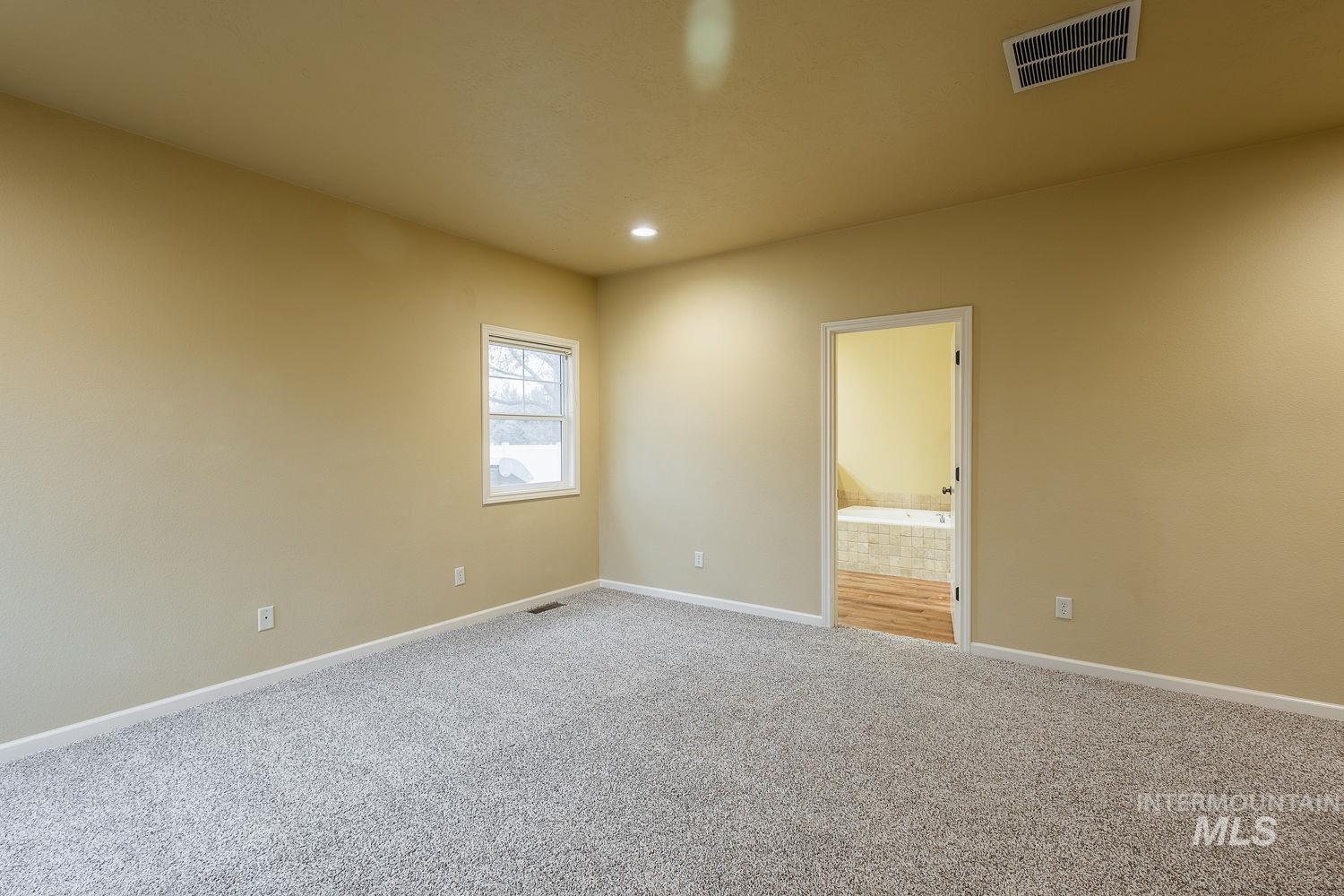 Carpeted spare room with baseboards and recessed lighting