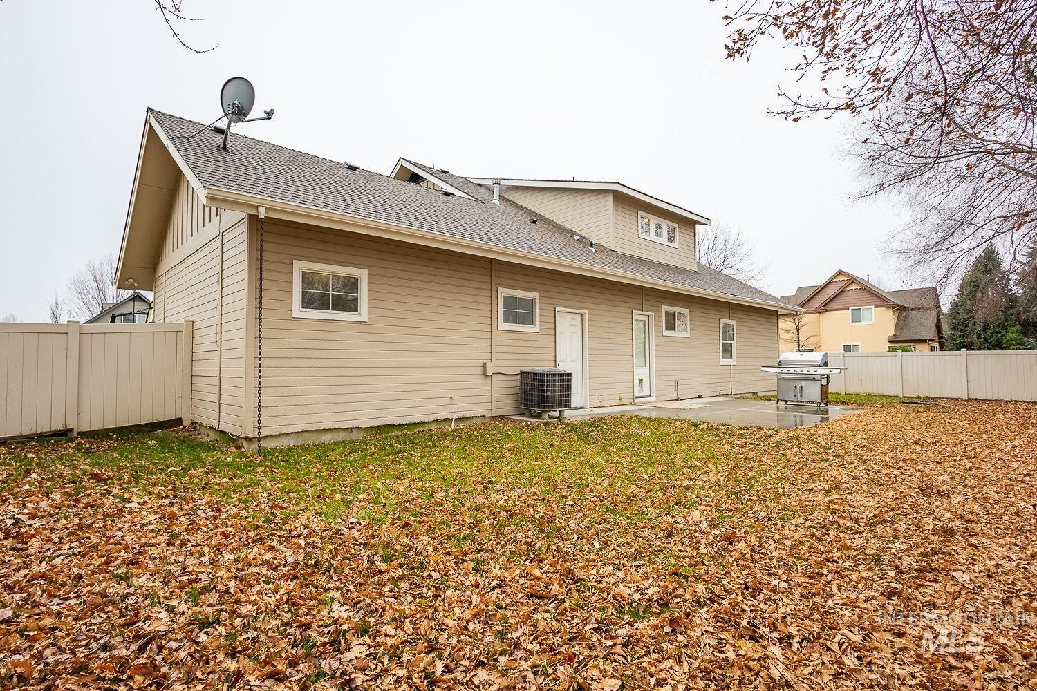 Back of property featuring a fenced backyard, a patio, and roof with shingles