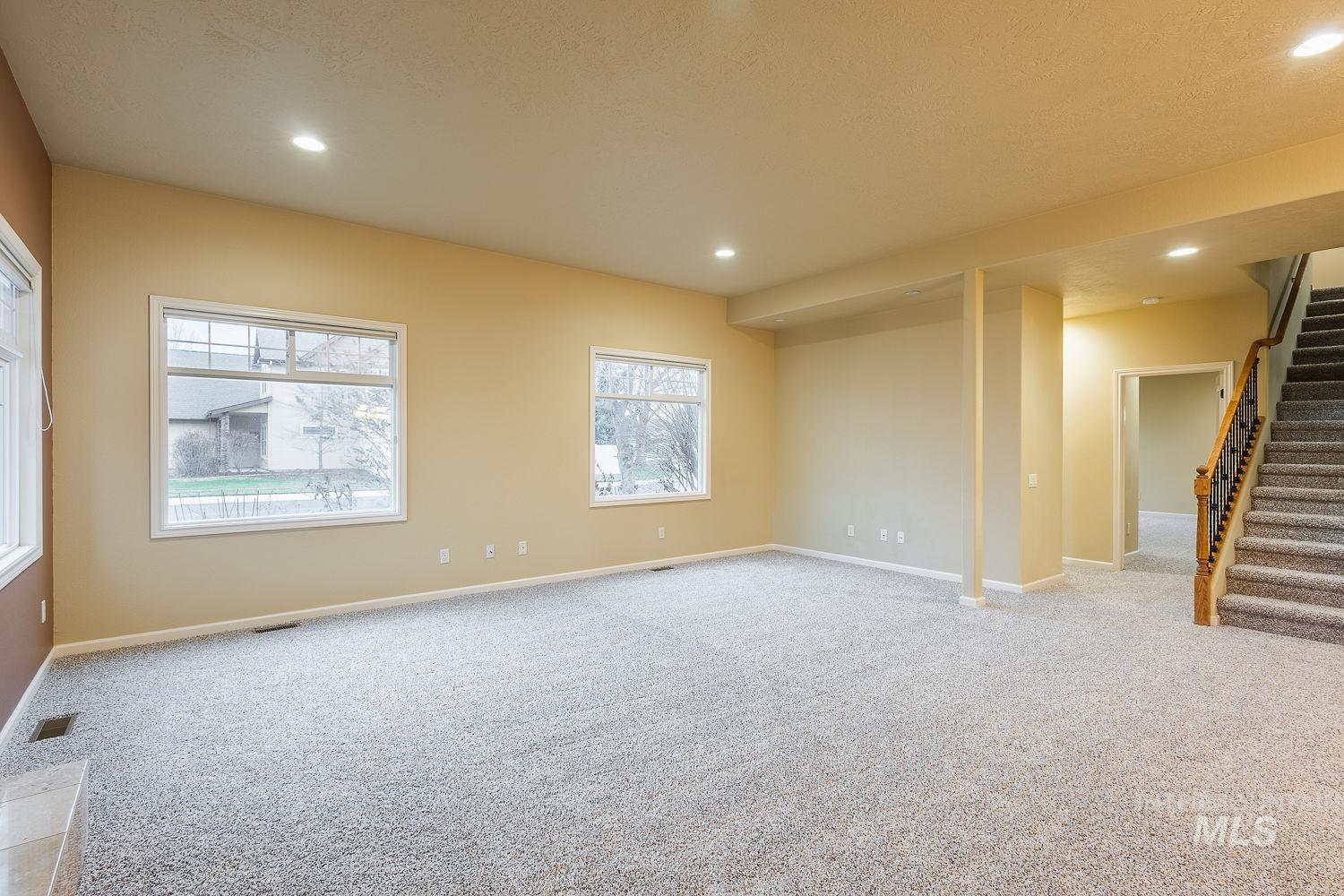 Unfurnished room with stairs, light colored carpet, recessed lighting, and a textured ceiling