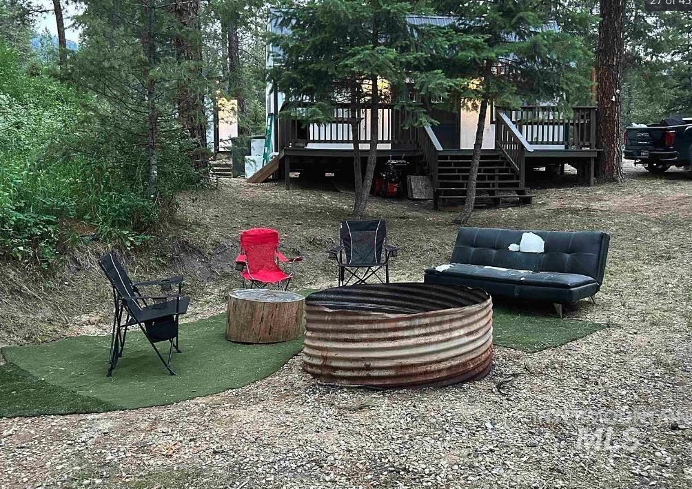 View of patio featuring a fire pit, stairs, and a deck