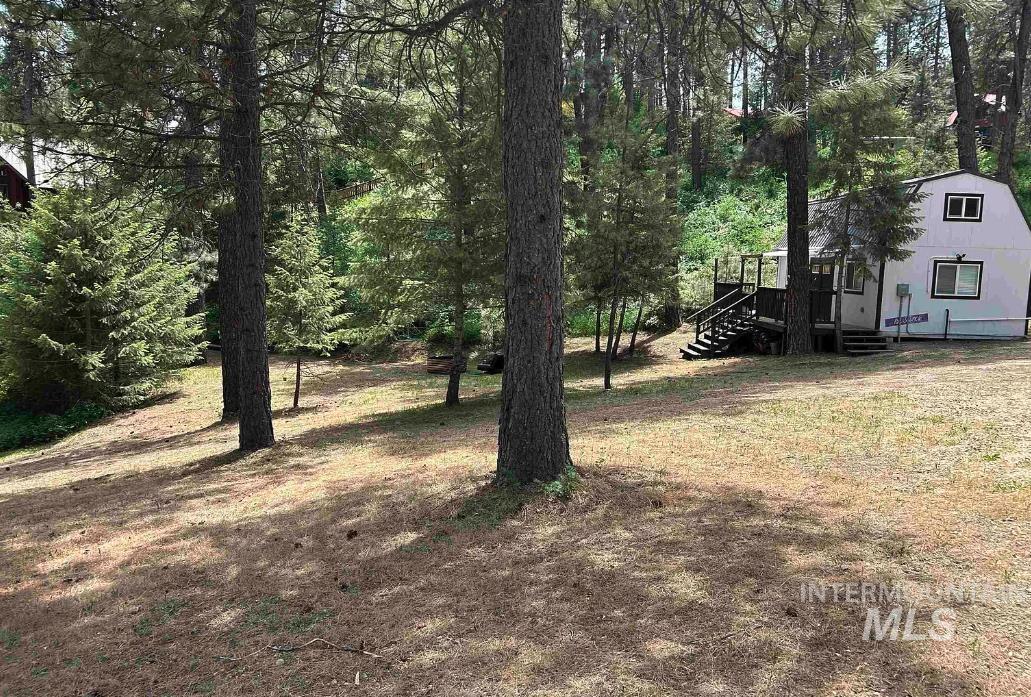 View of green lawn featuring a view of trees