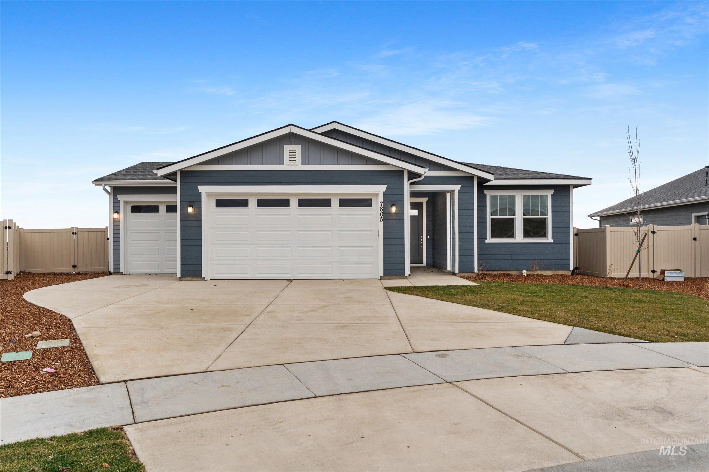 Single story home featuring board and batten siding, a gate, driveway, a garage, and a shingled roof
