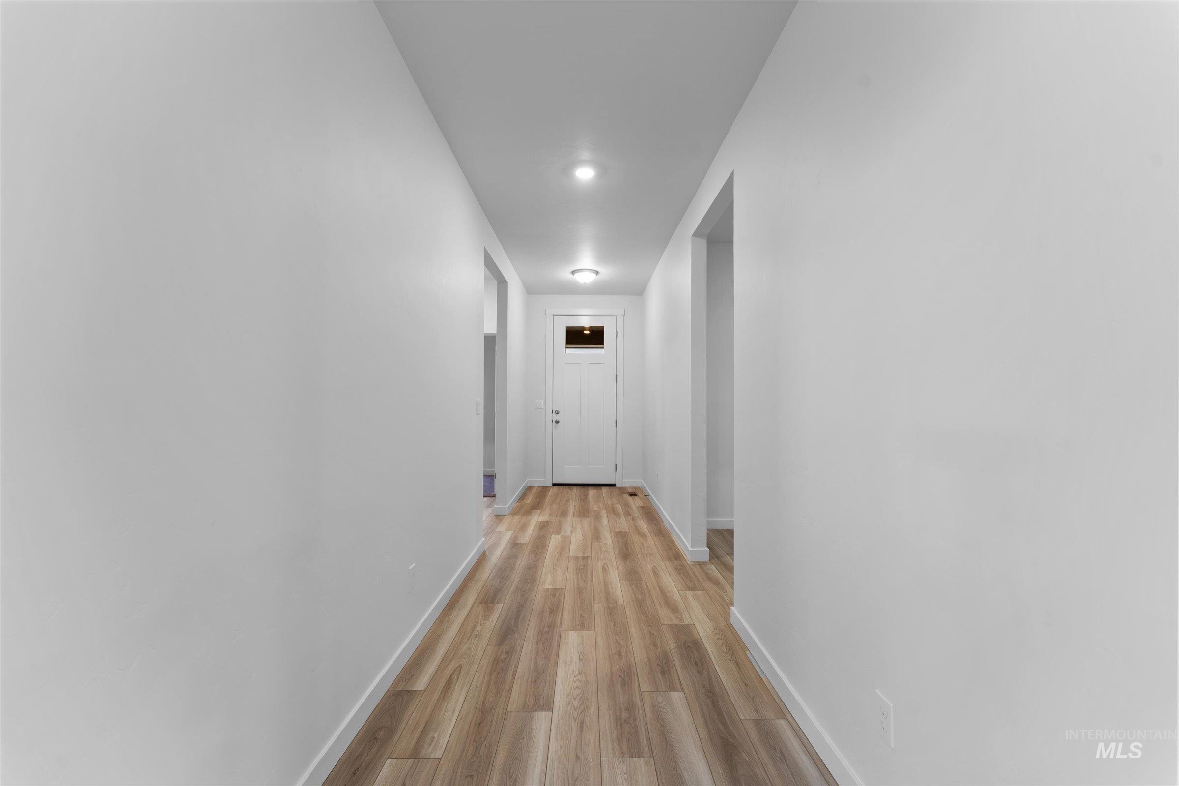 Hallway featuring baseboards and light wood-style floors