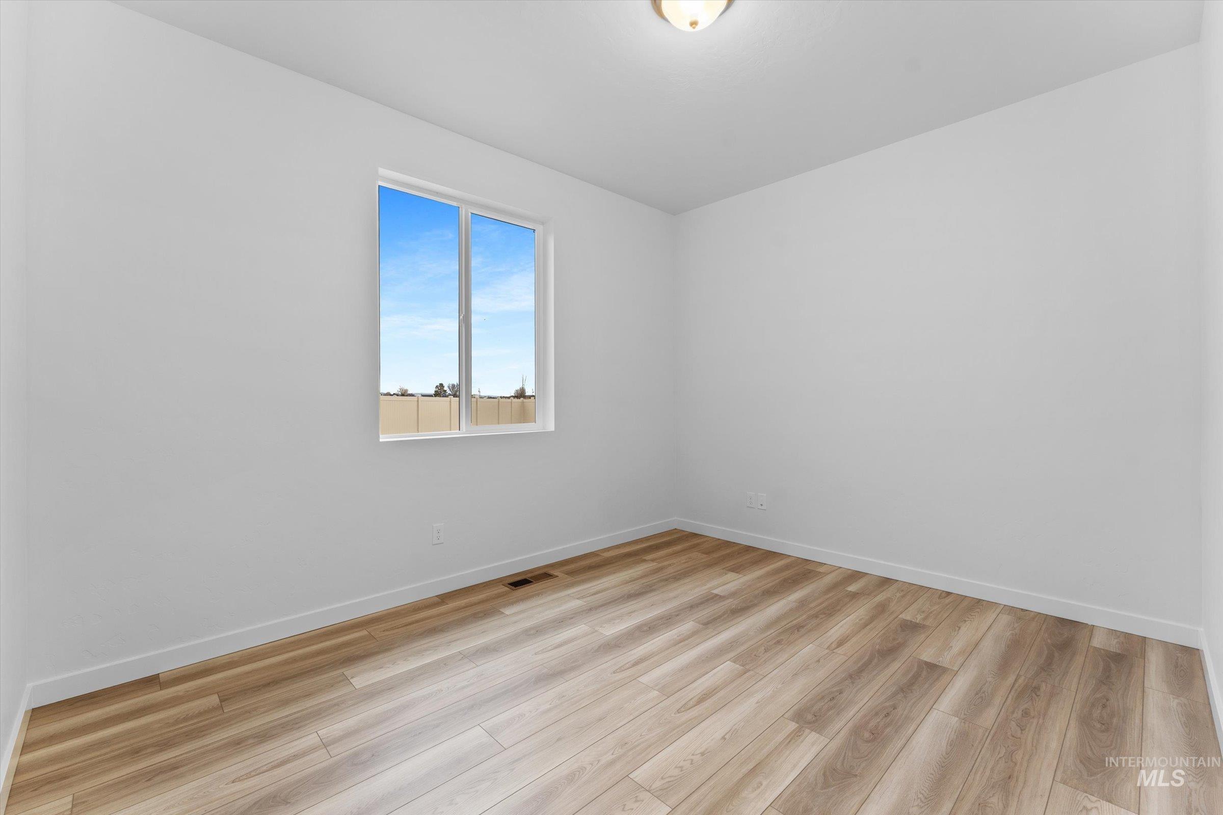 Empty room with light wood-style floors and baseboards