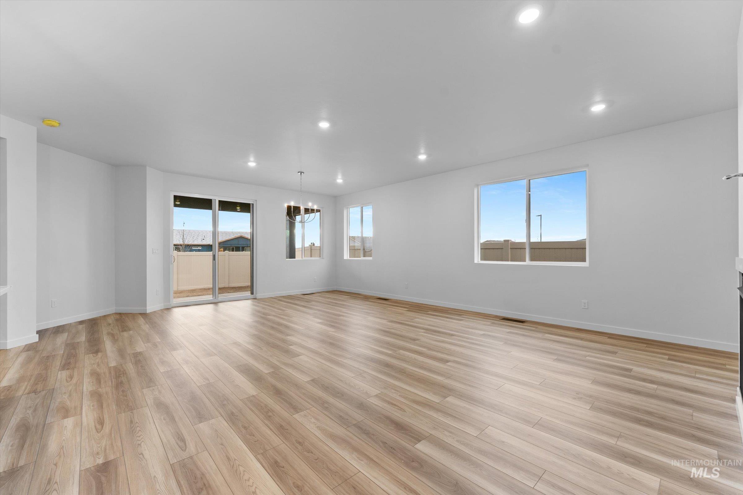 Spare room featuring light wood-type flooring, a chandelier, and recessed lighting