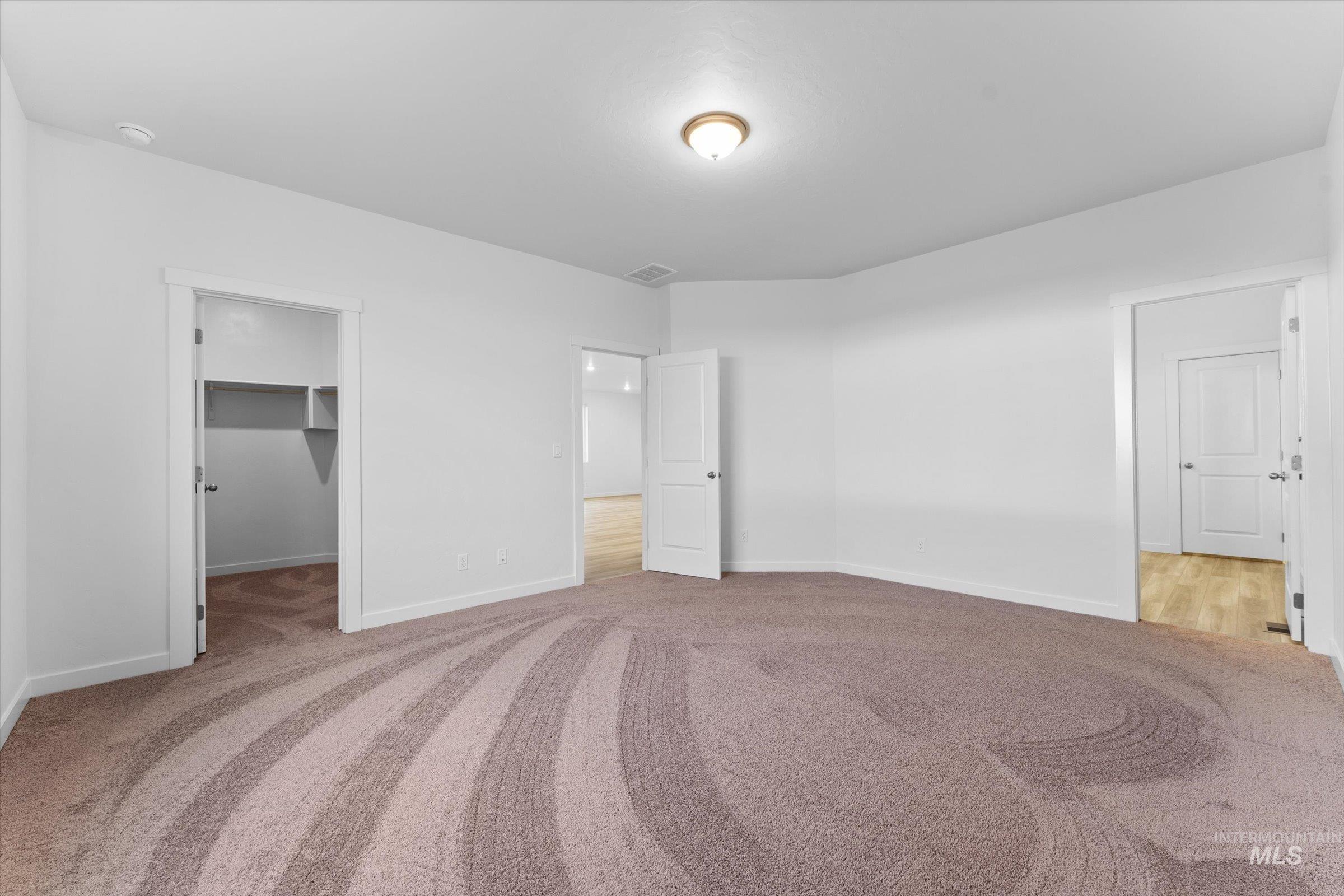 Unfurnished bedroom featuring a spacious closet and light carpet