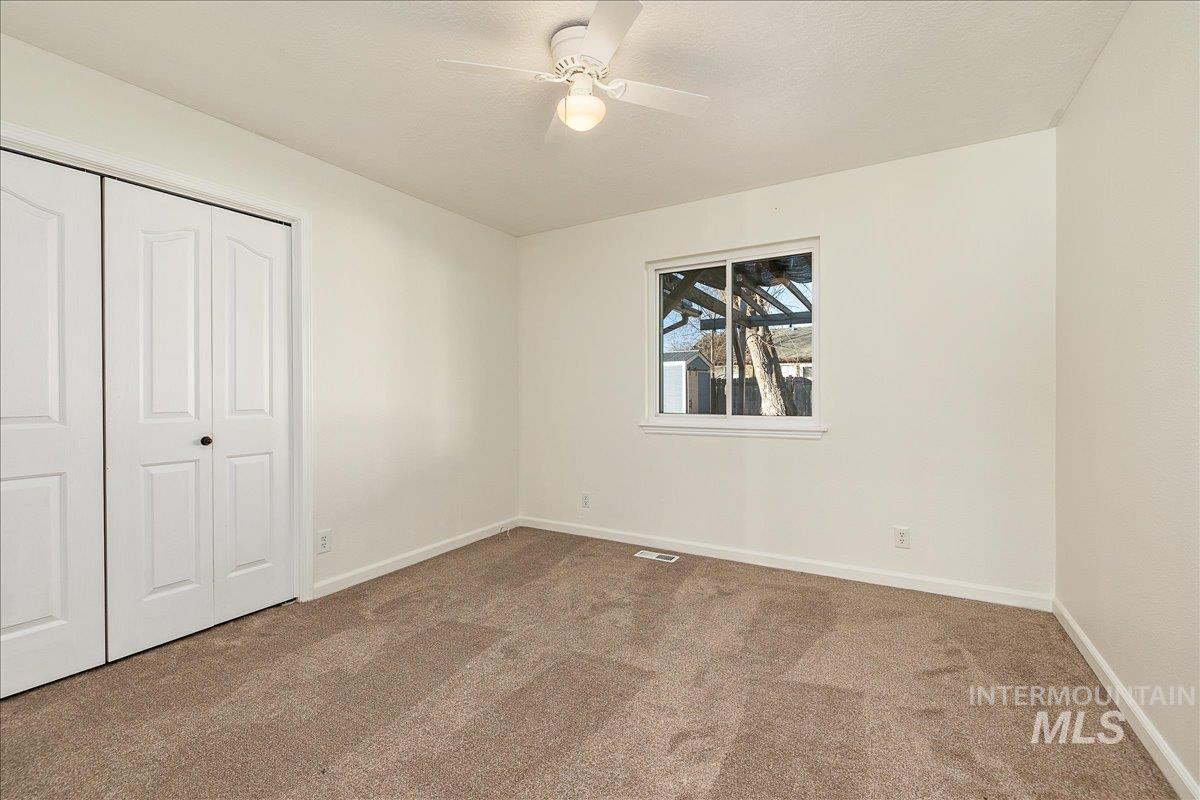 Unfurnished bedroom featuring a closet, carpet floors, and a ceiling fan