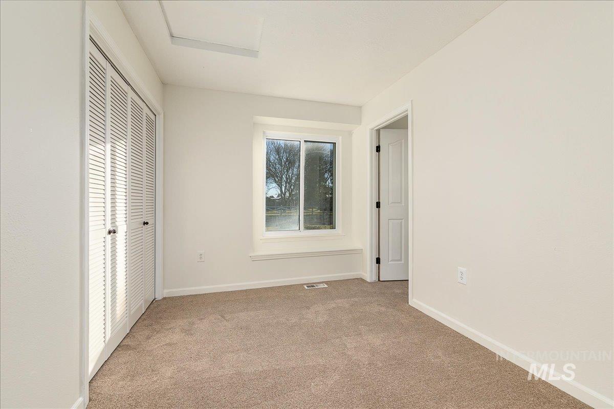 Unfurnished bedroom featuring light carpet and a closet