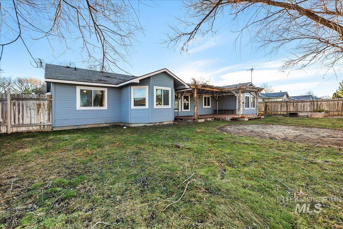 Back of property featuring a wooden deck and roof with shingles