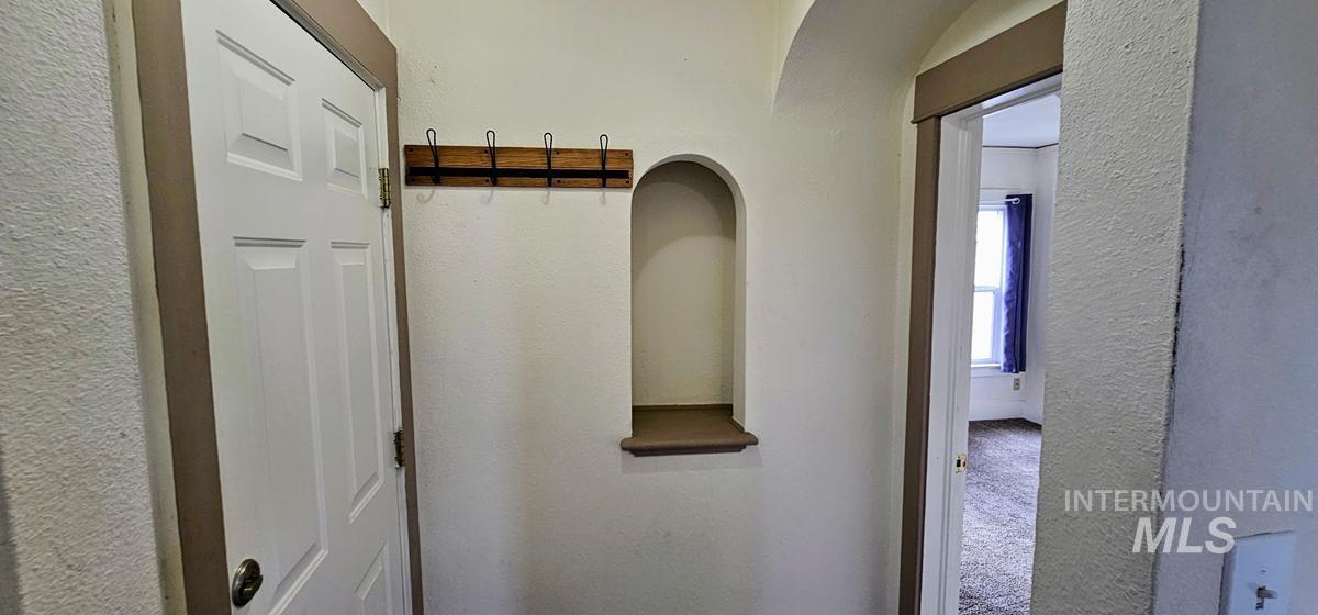 Mudroom featuring a textured wall and carpet flooring