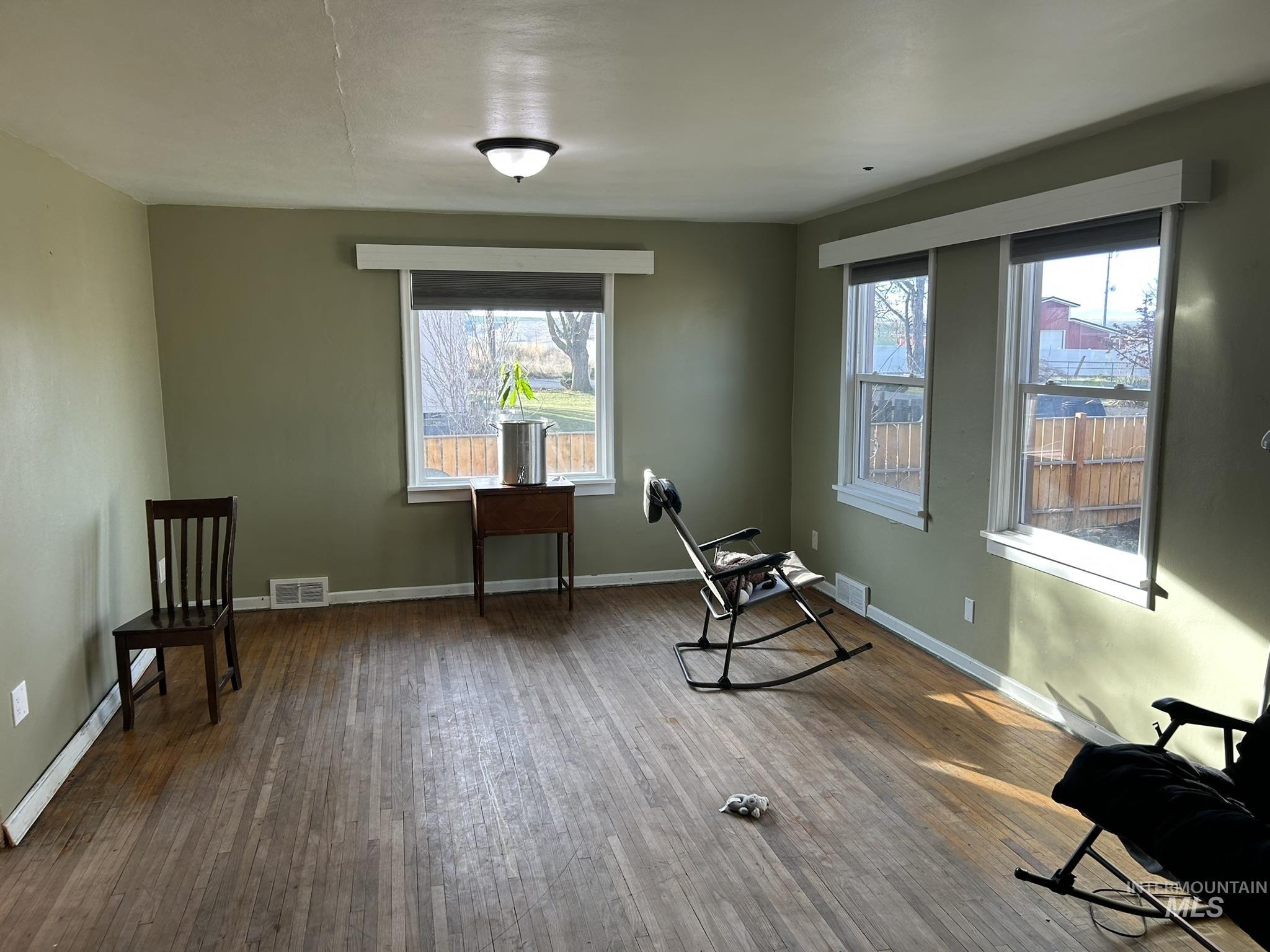 Sitting room featuring plenty of natural light and dark wood-style floors