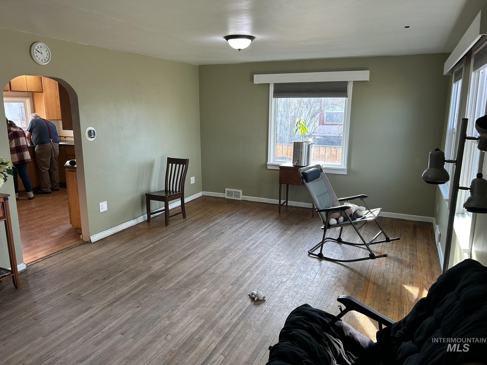 Exercise area with arched walkways, healthy amount of natural light, and light wood-style flooring