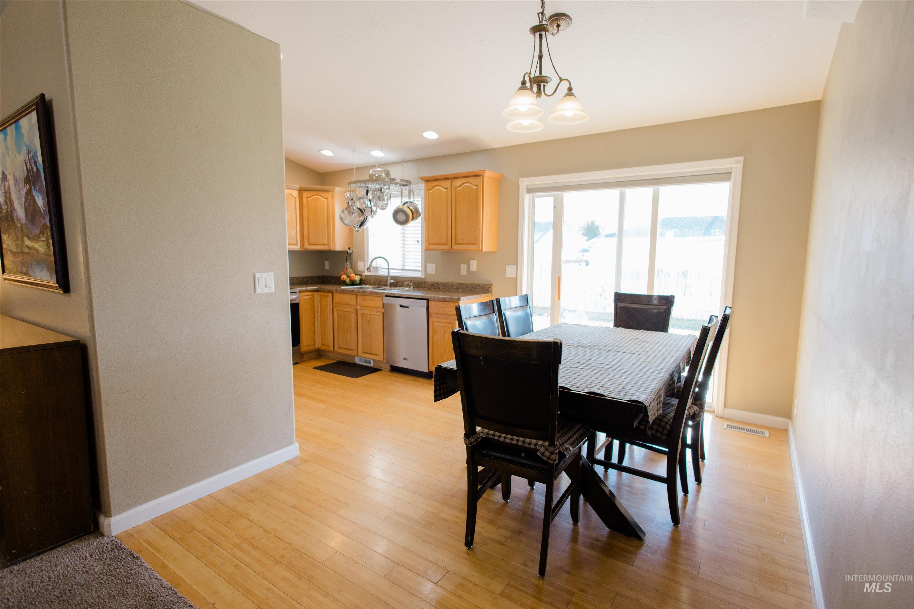 Dining space with a chandelier, light wood-style floors, and recessed lighting