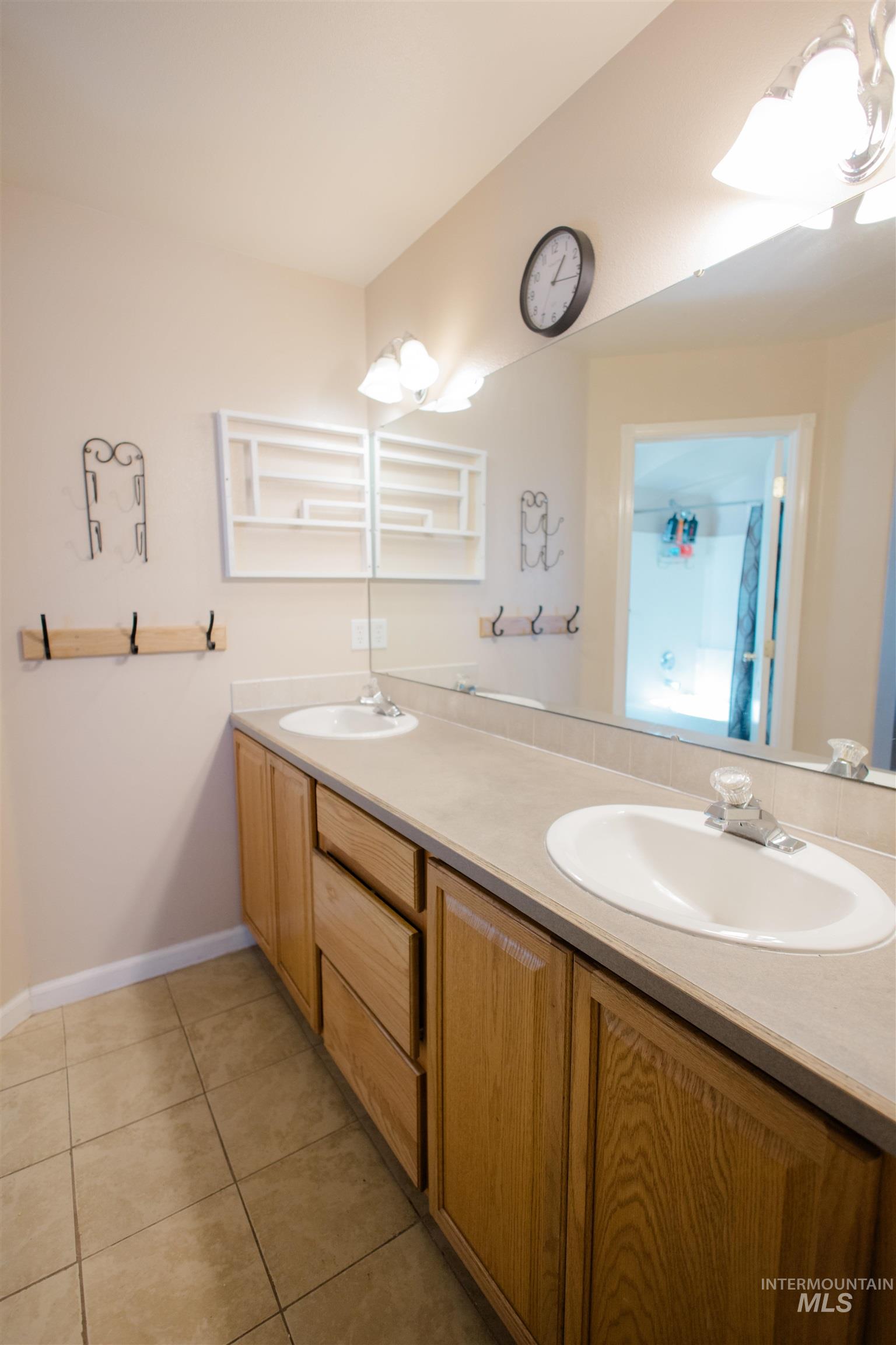 Full bathroom with double vanity and light tile patterned floors