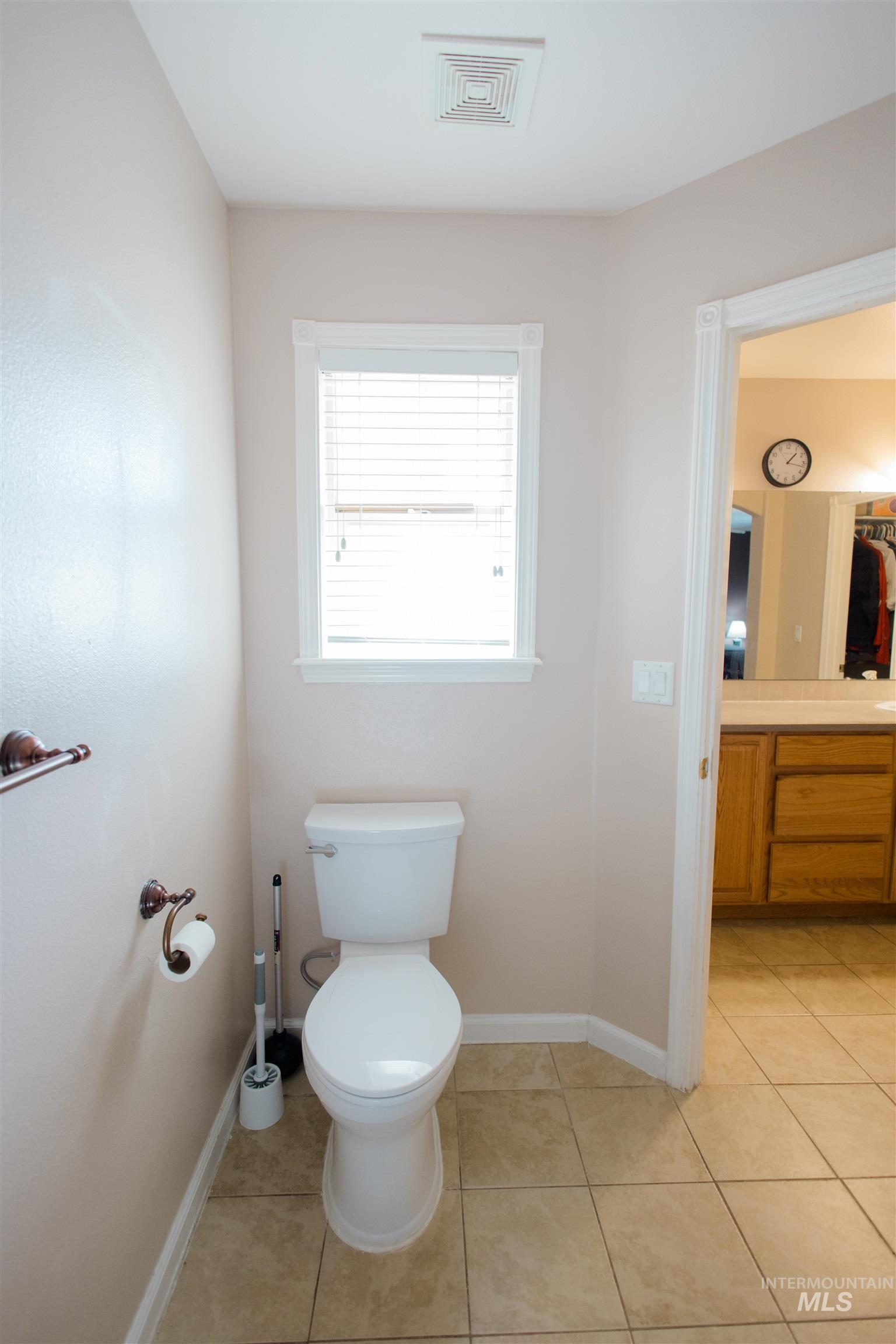 Bathroom with light tile patterned floors and vanity
