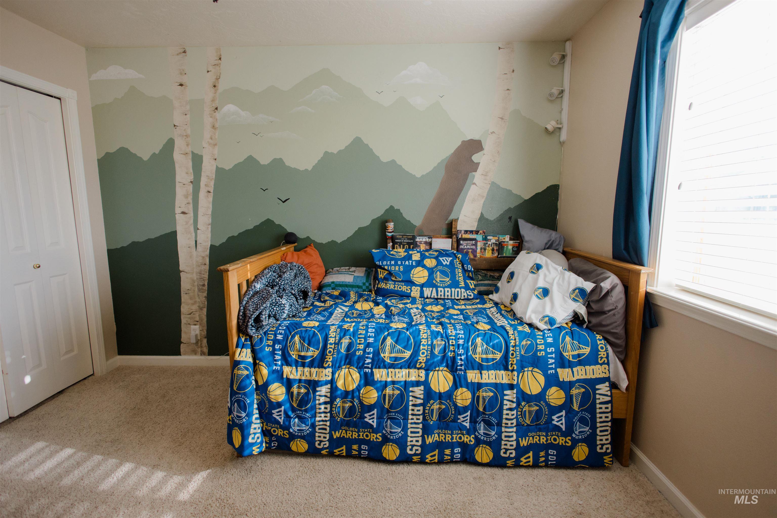 Carpeted bedroom featuring multiple windows and a closet