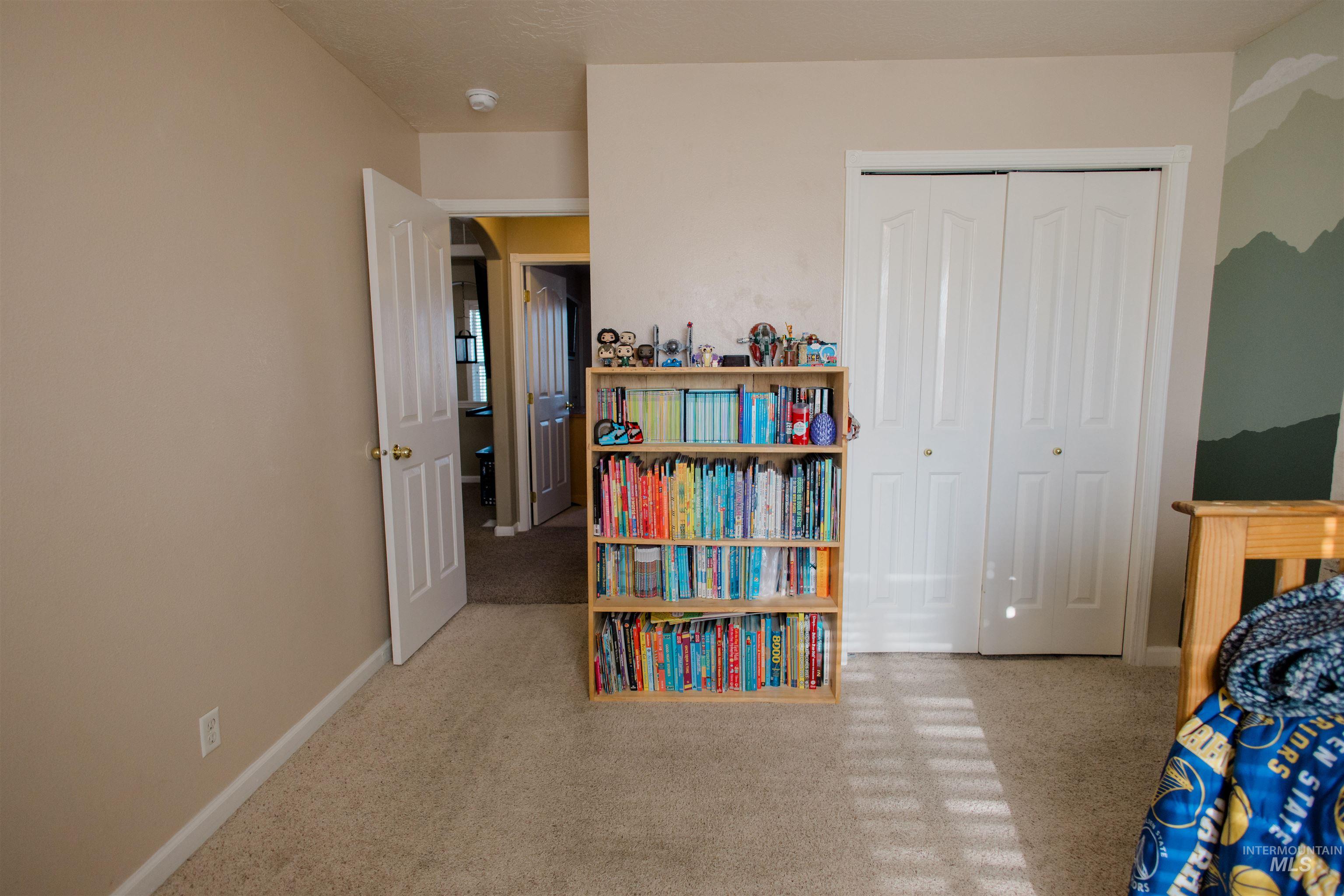 Bedroom featuring light colored carpet and a closet