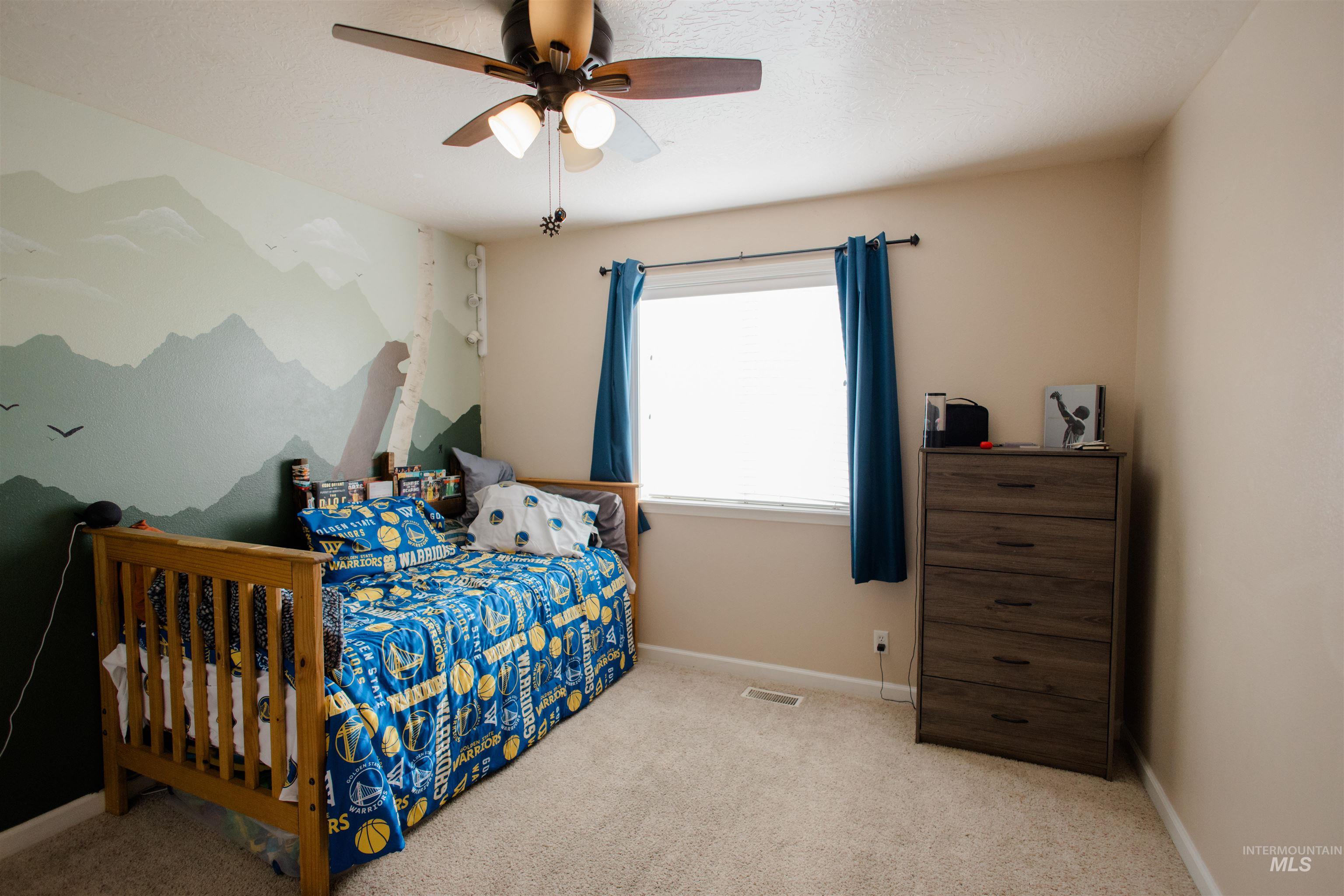 Bedroom with light colored carpet and a ceiling fan