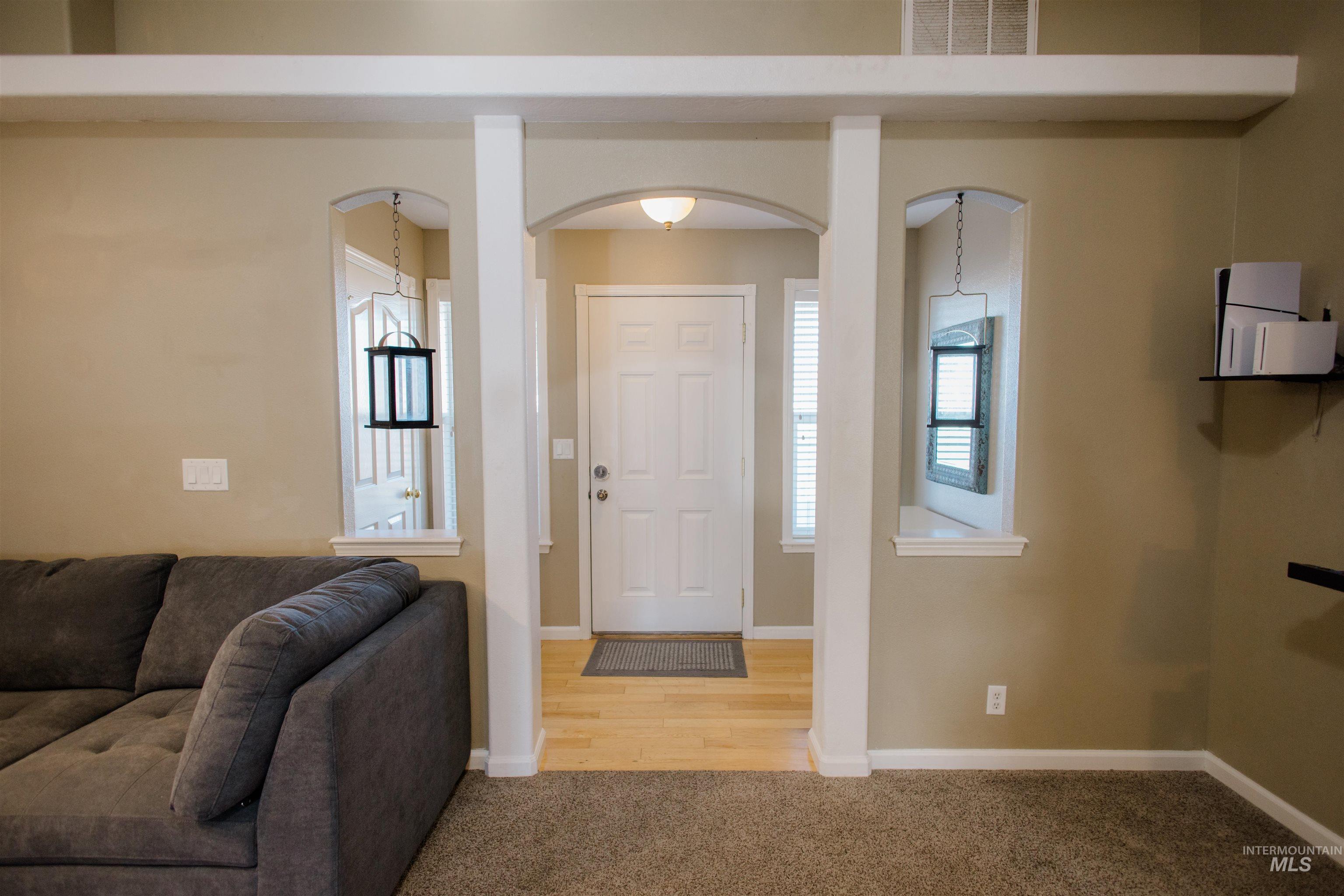 Carpeted entrance foyer featuring arched walkways and healthy amount of natural light