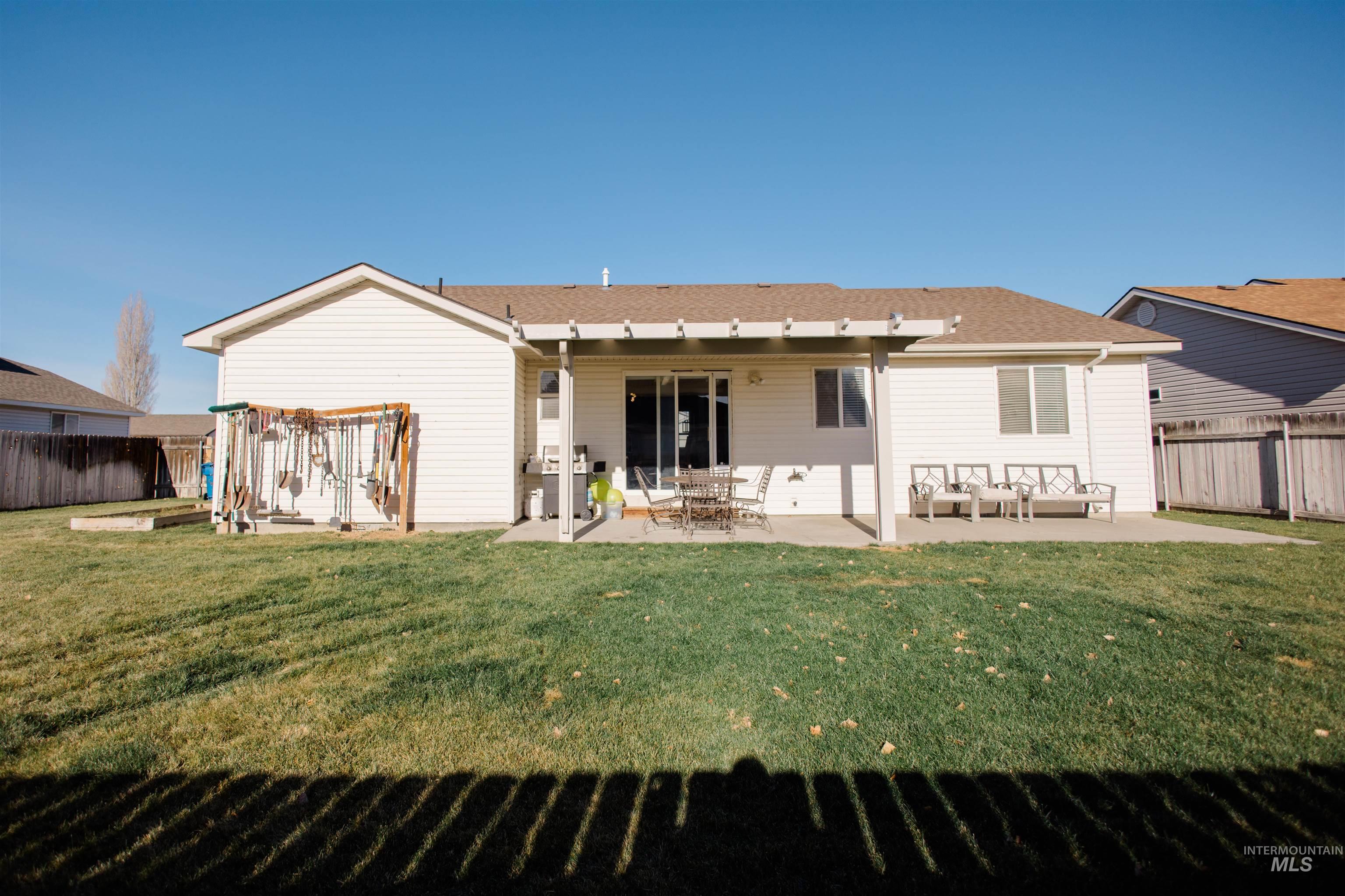 Back of house with a fenced backyard, a patio, and a shingled roof
