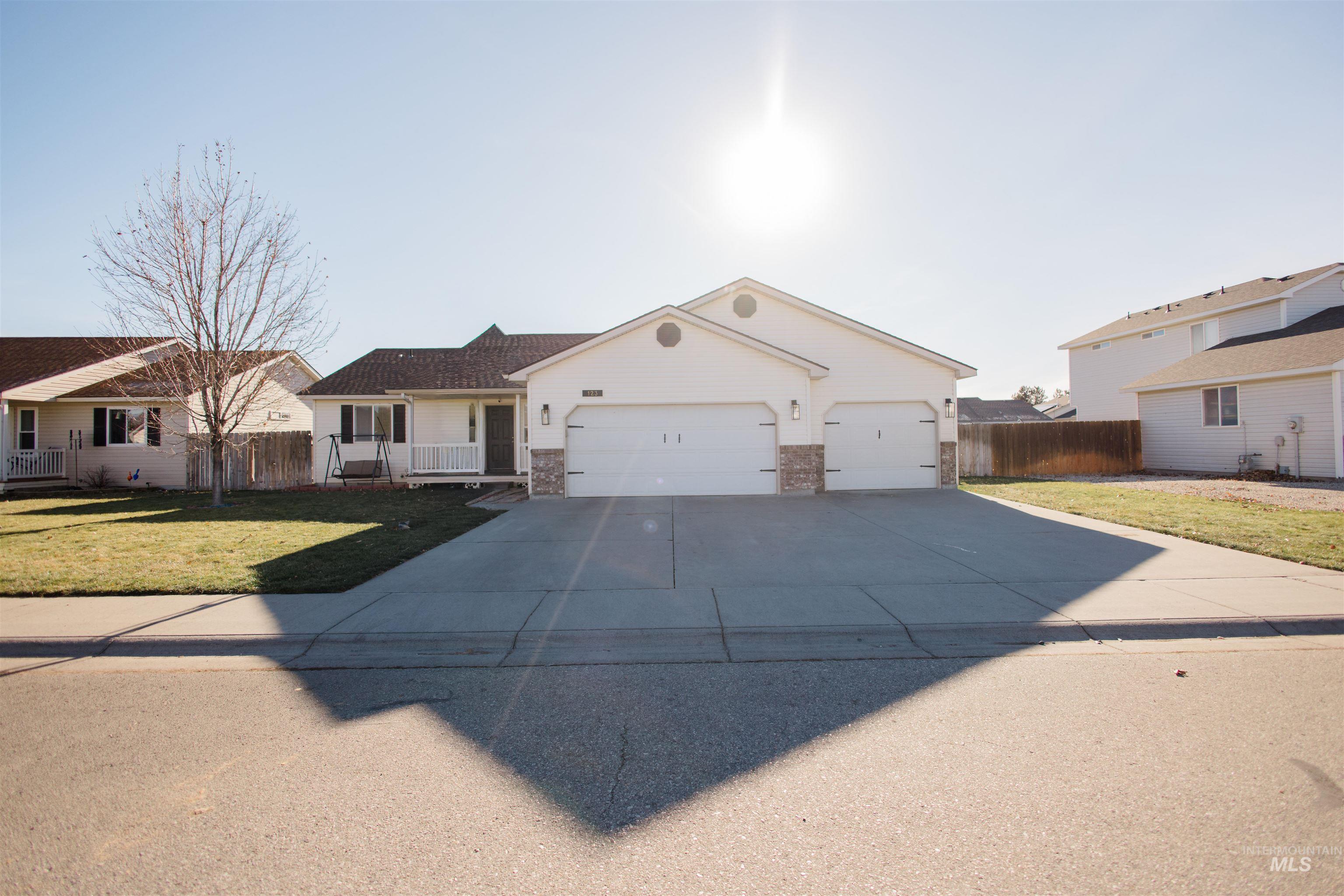 Ranch-style home featuring concrete driveway, a porch, and an attached garage