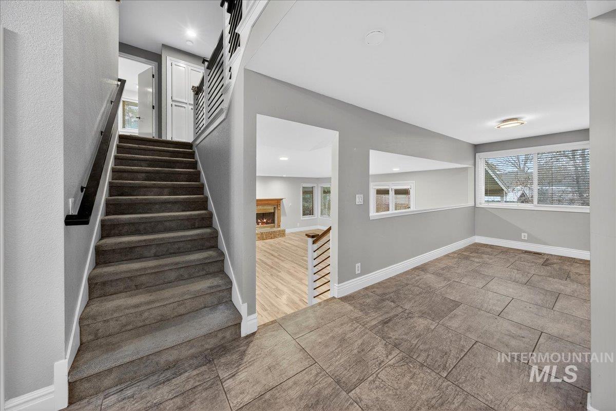 Stairs featuring a lit fireplace and recessed lighting