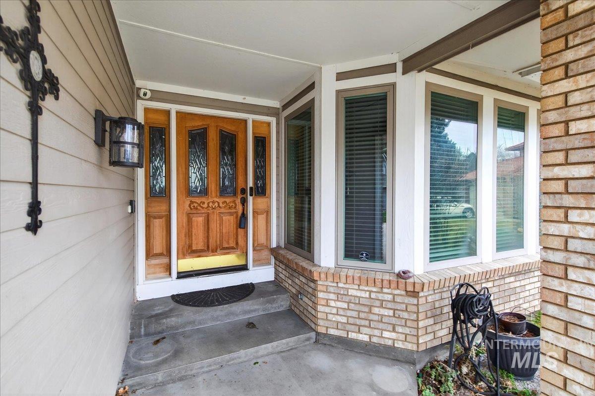 Property entrance with brick siding and a porch