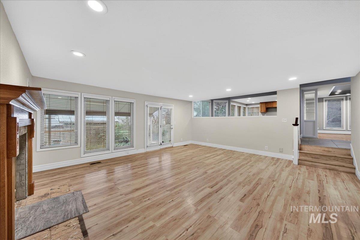 Unfurnished living room featuring light wood-style floors, a fireplace, and recessed lighting