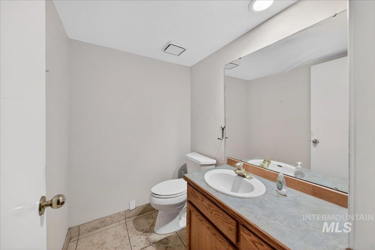 Half bath with vanity and light tile patterned floors