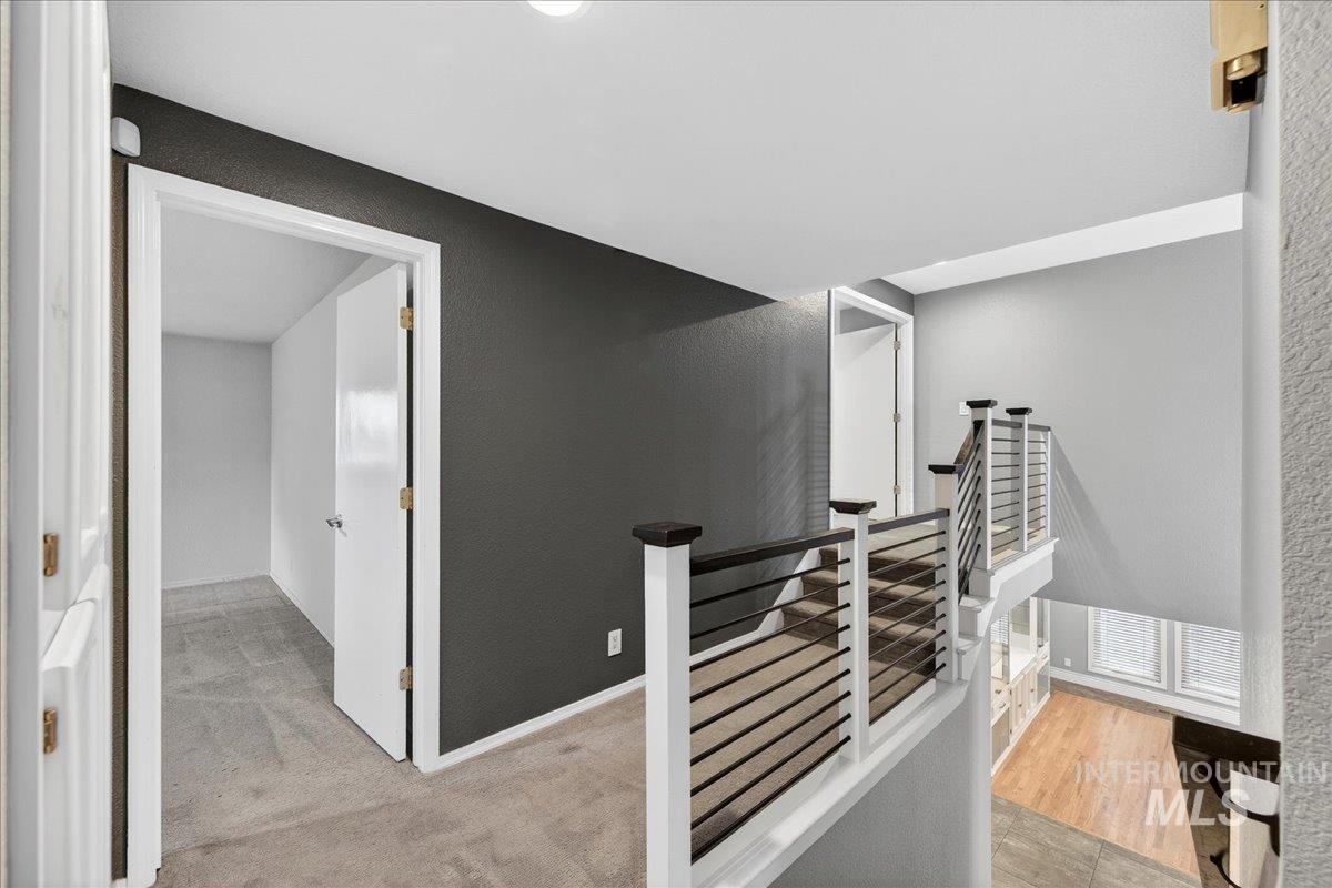 Stairway featuring a textured wall and carpet flooring