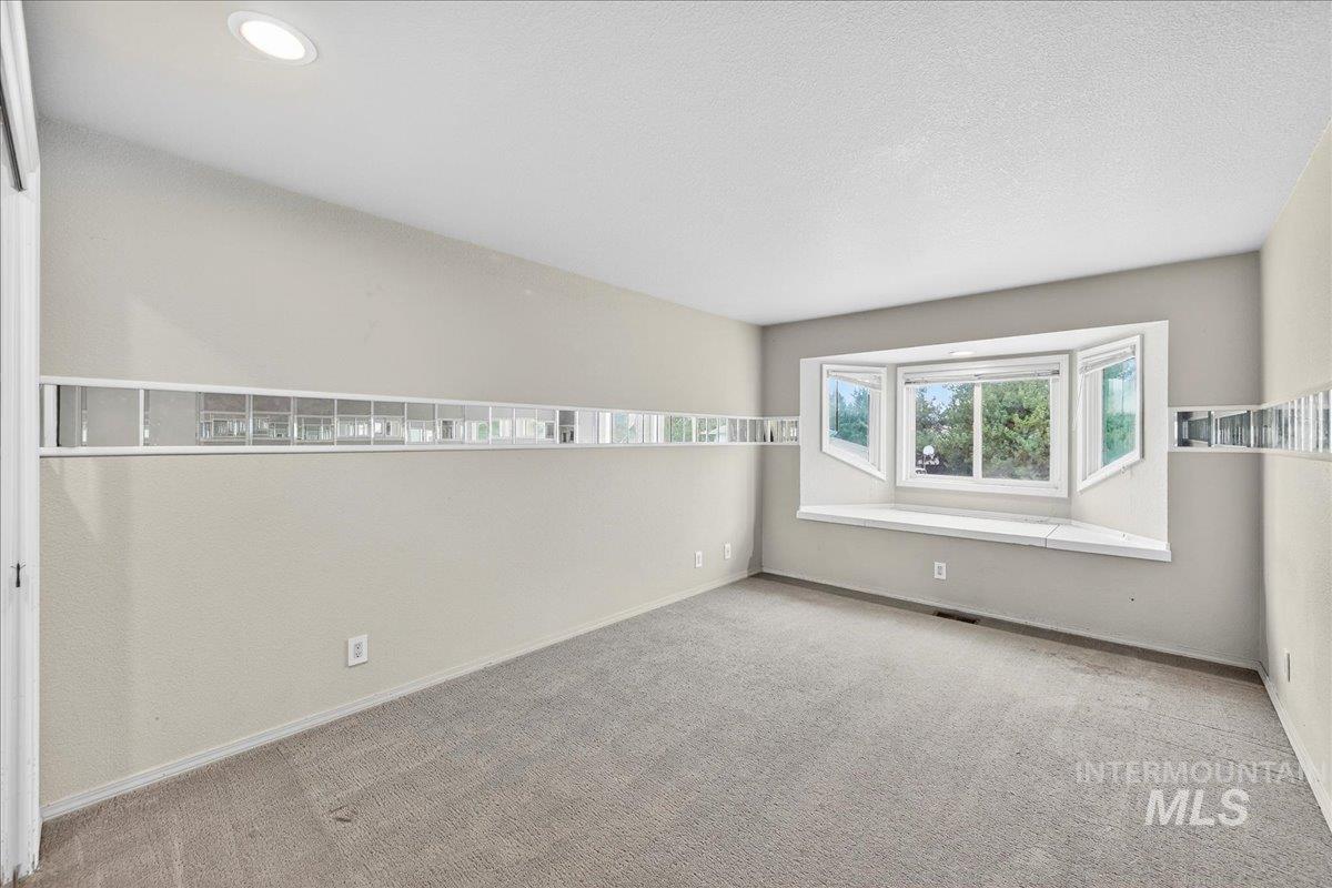 Carpeted empty room with baseboards